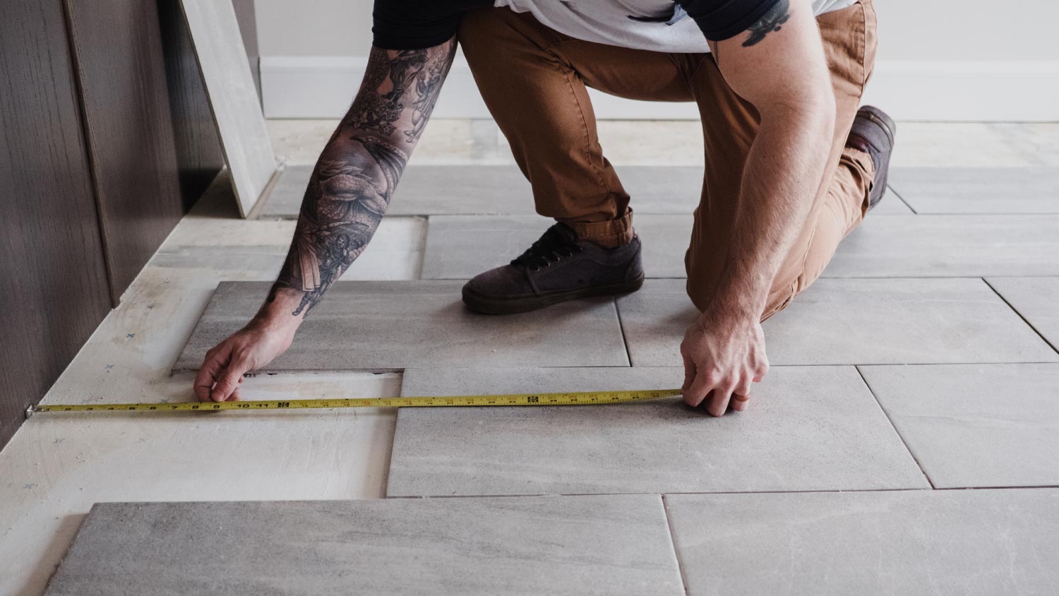 A man measuring floor tiles