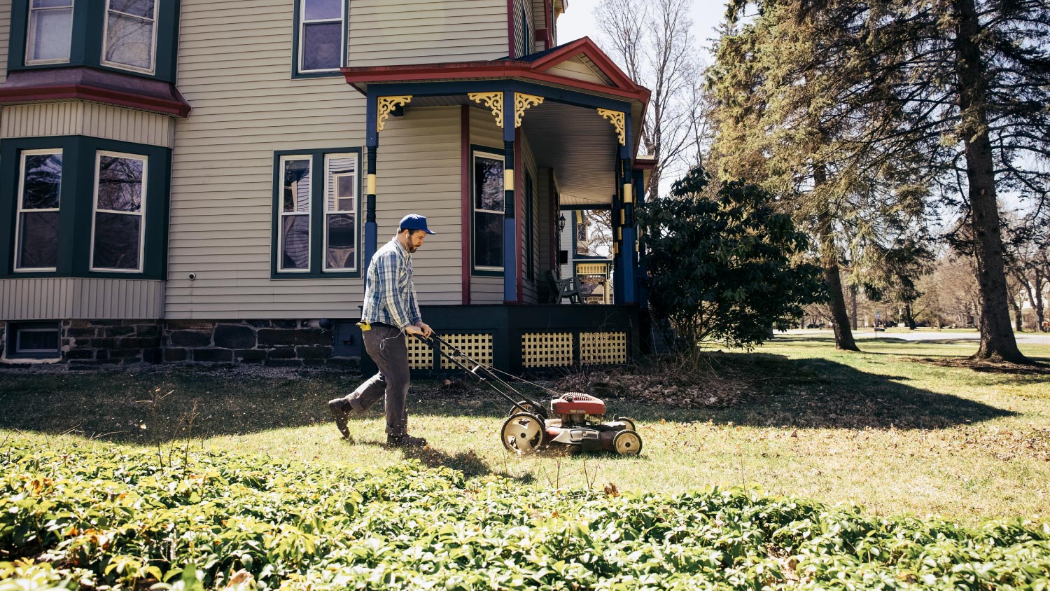 A man mowing grass on a sunny day