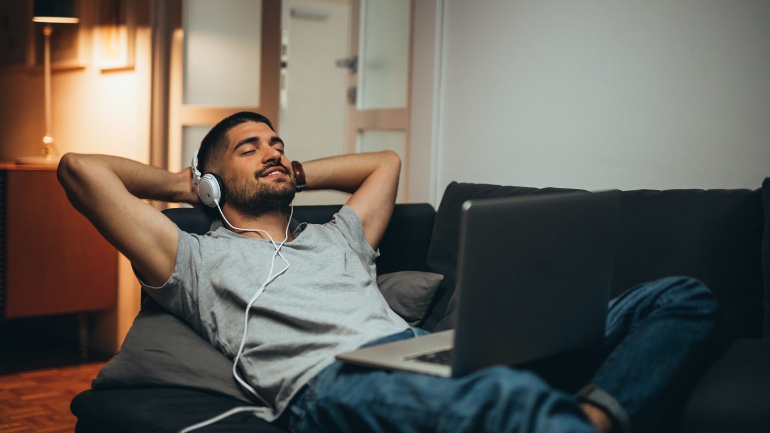 A man relaxing in the sofa while listening to music