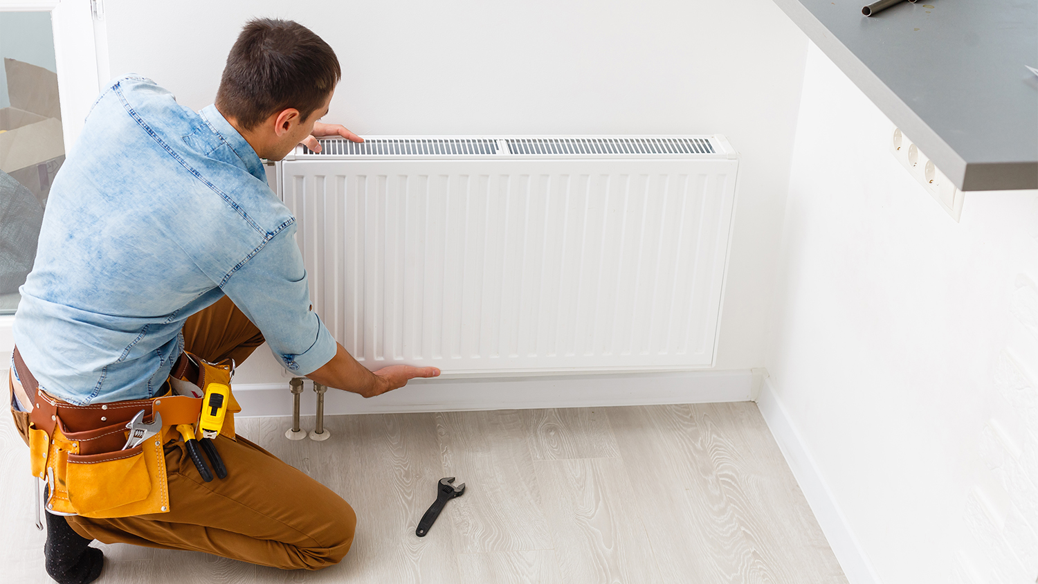 man repairing radiator in home  