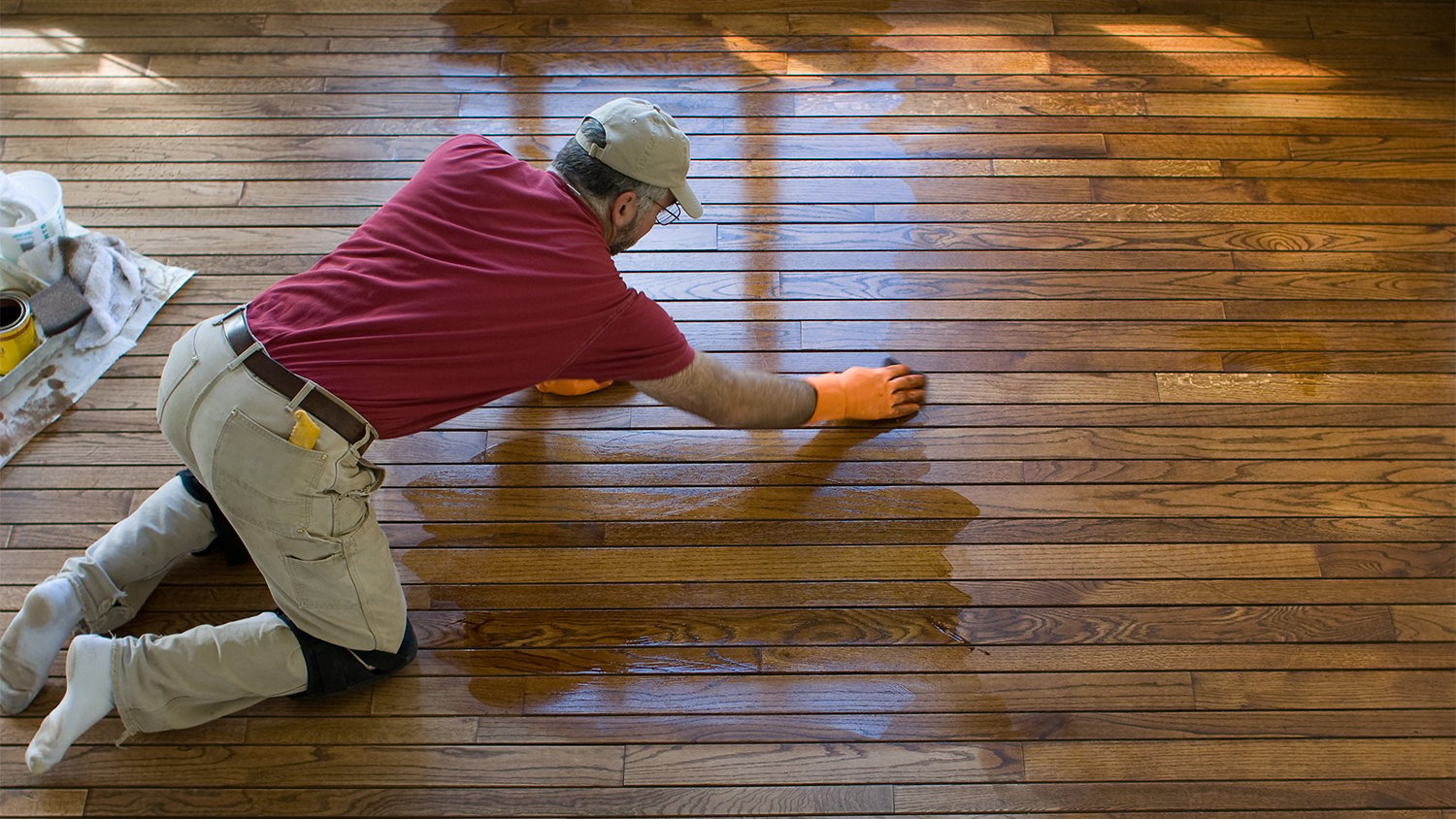 Carpenter staining a hardwood floor