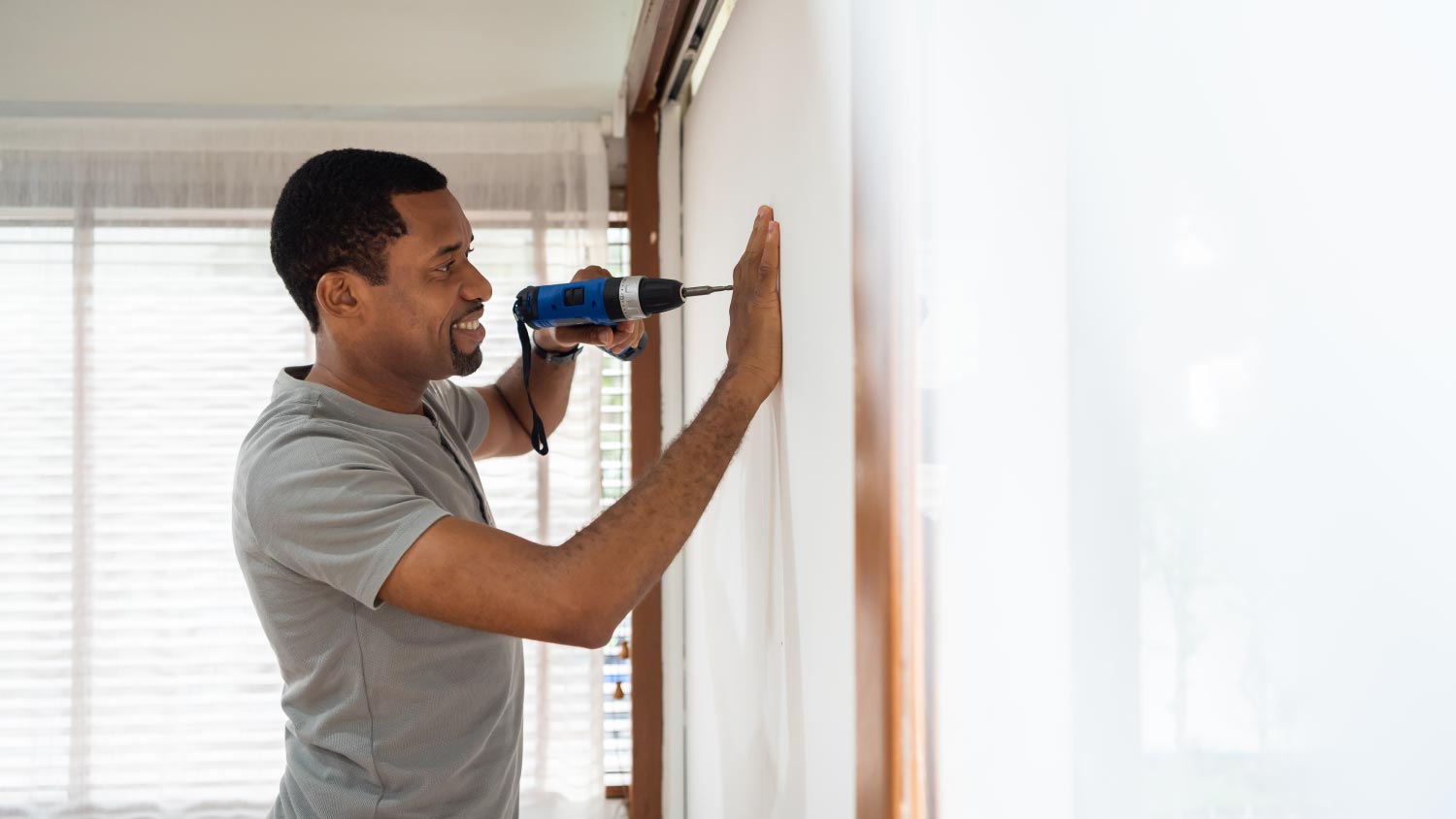 A man using electric drill on the wall