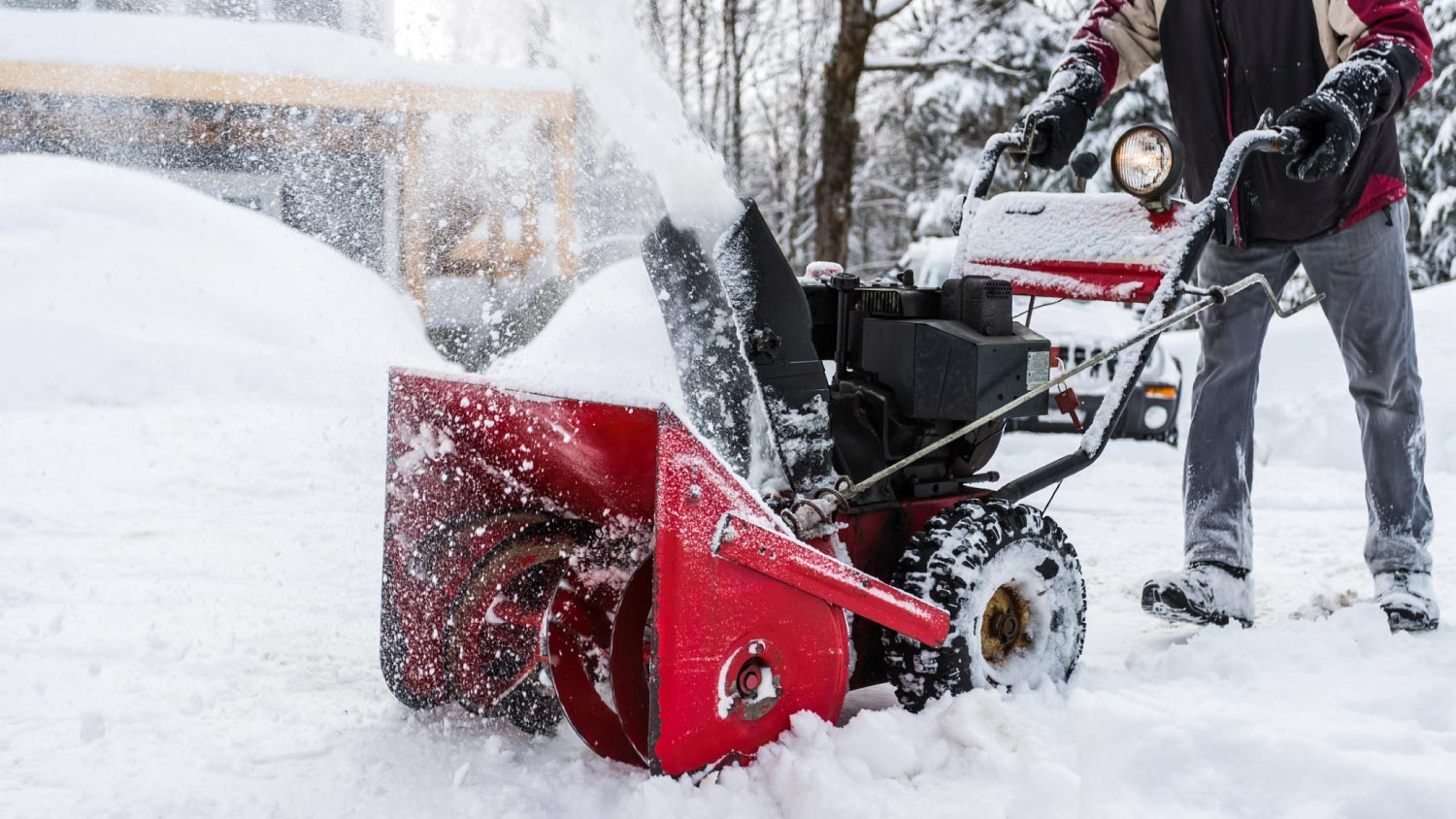 A man using snowblower after a snowstorm