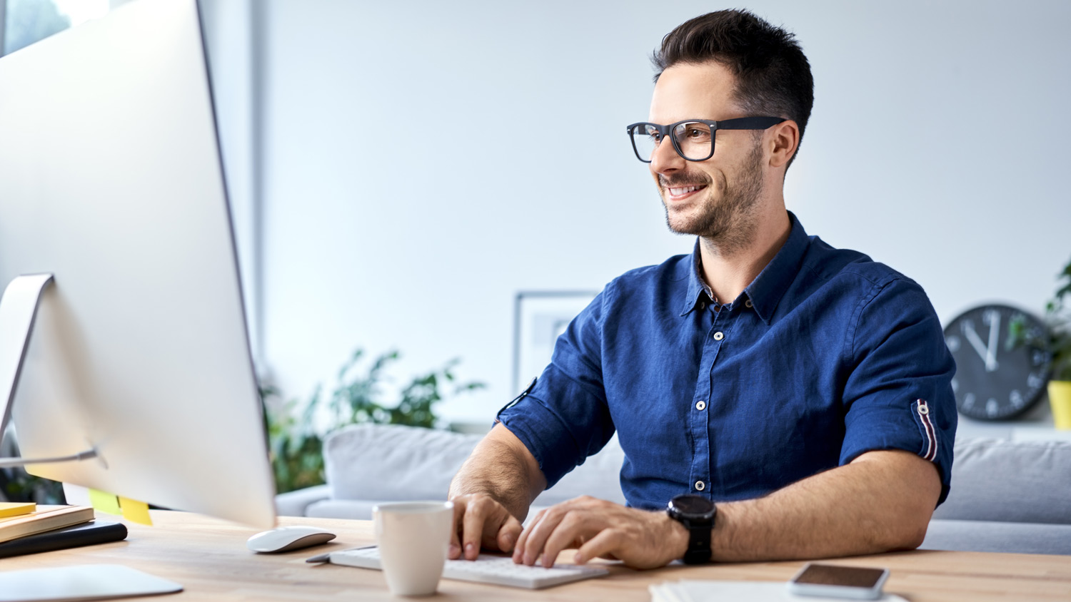 A man working from his home on a desktop computer