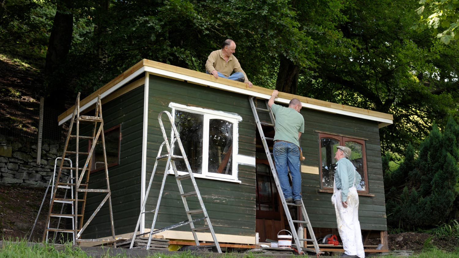 A group of men working on a garden shed structure