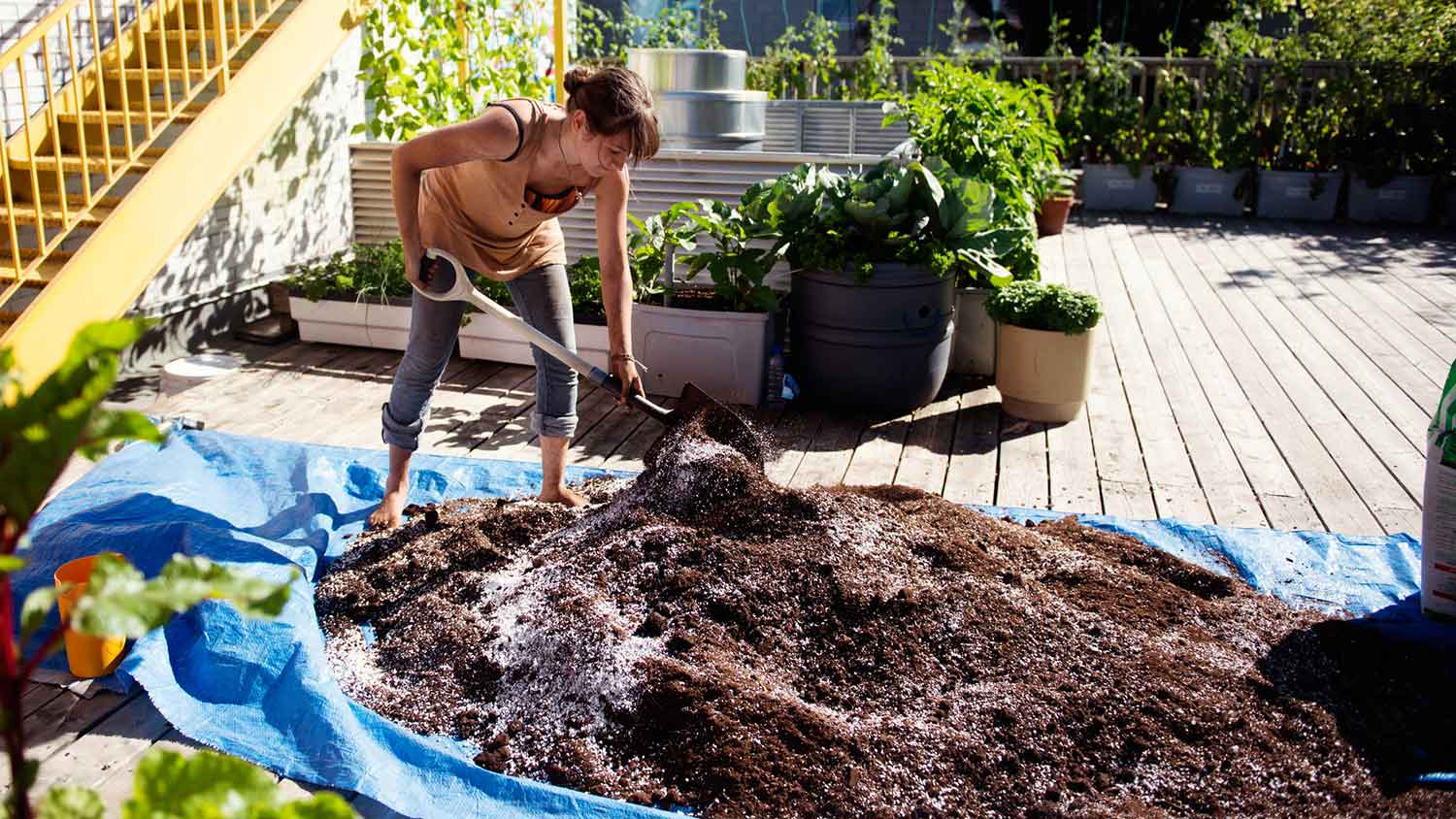 Woman mixing soil and compost with a shovel