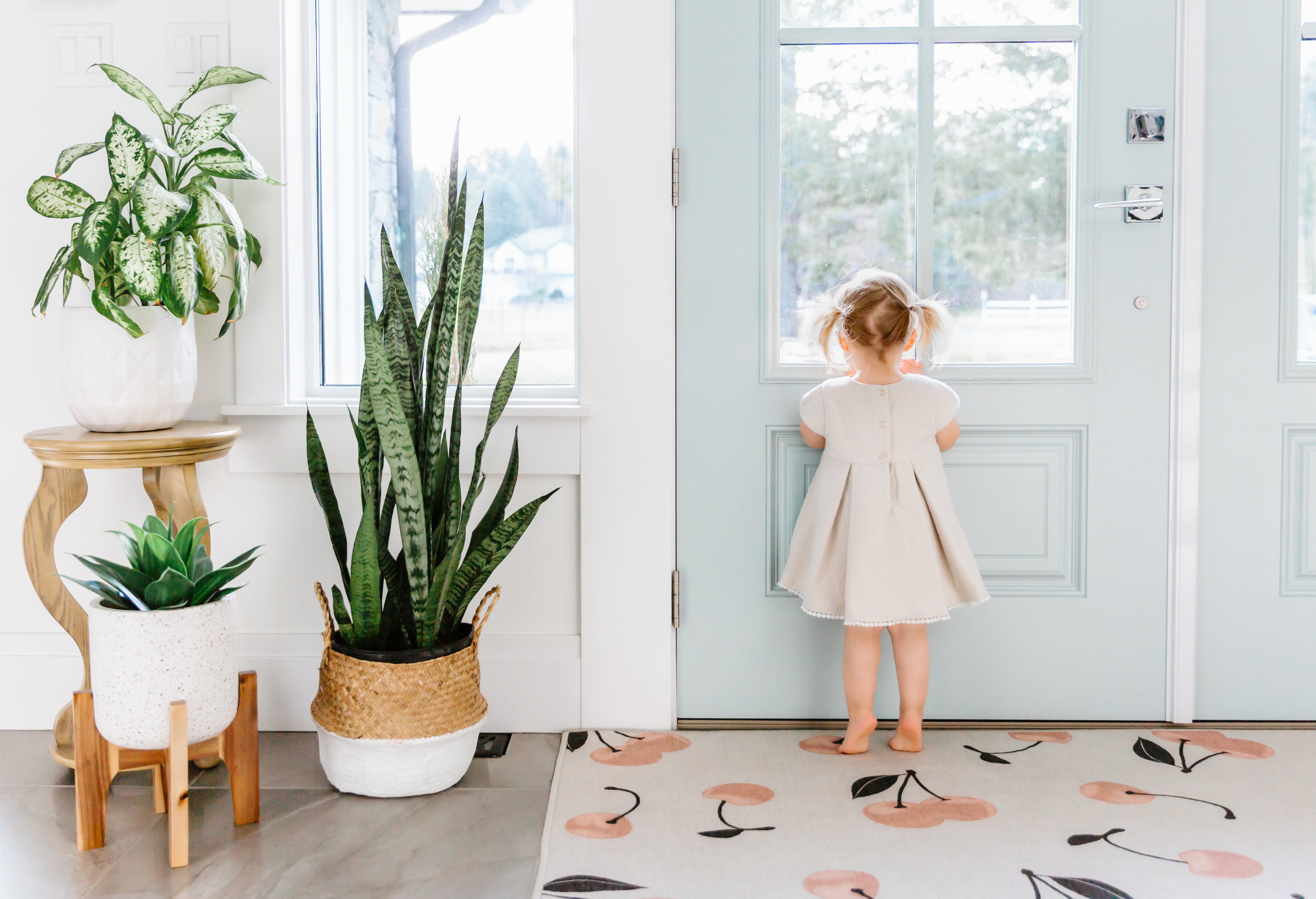 Little girl looking out blue front door