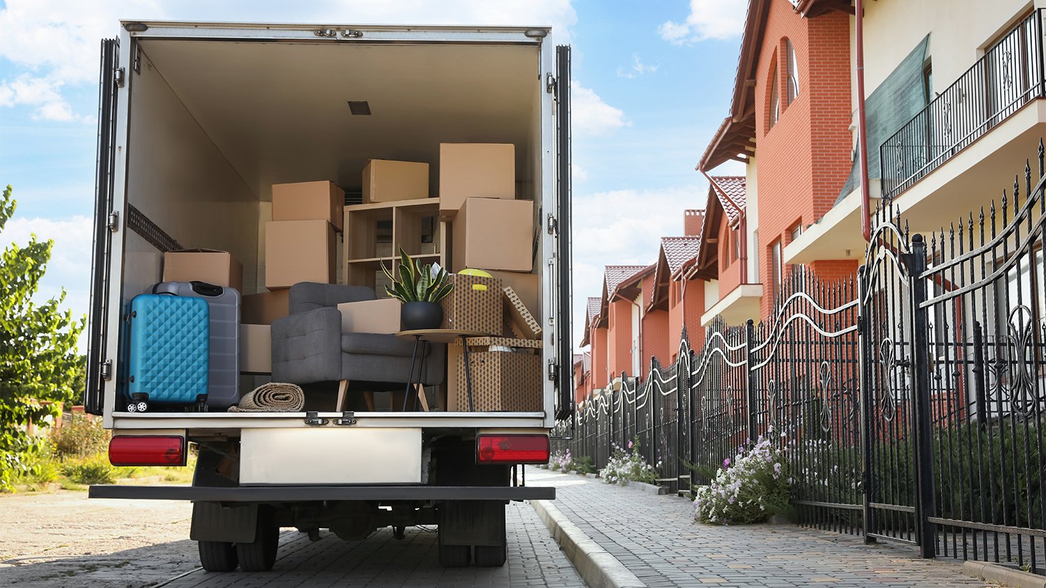 moving truck full of boxes outside of house   