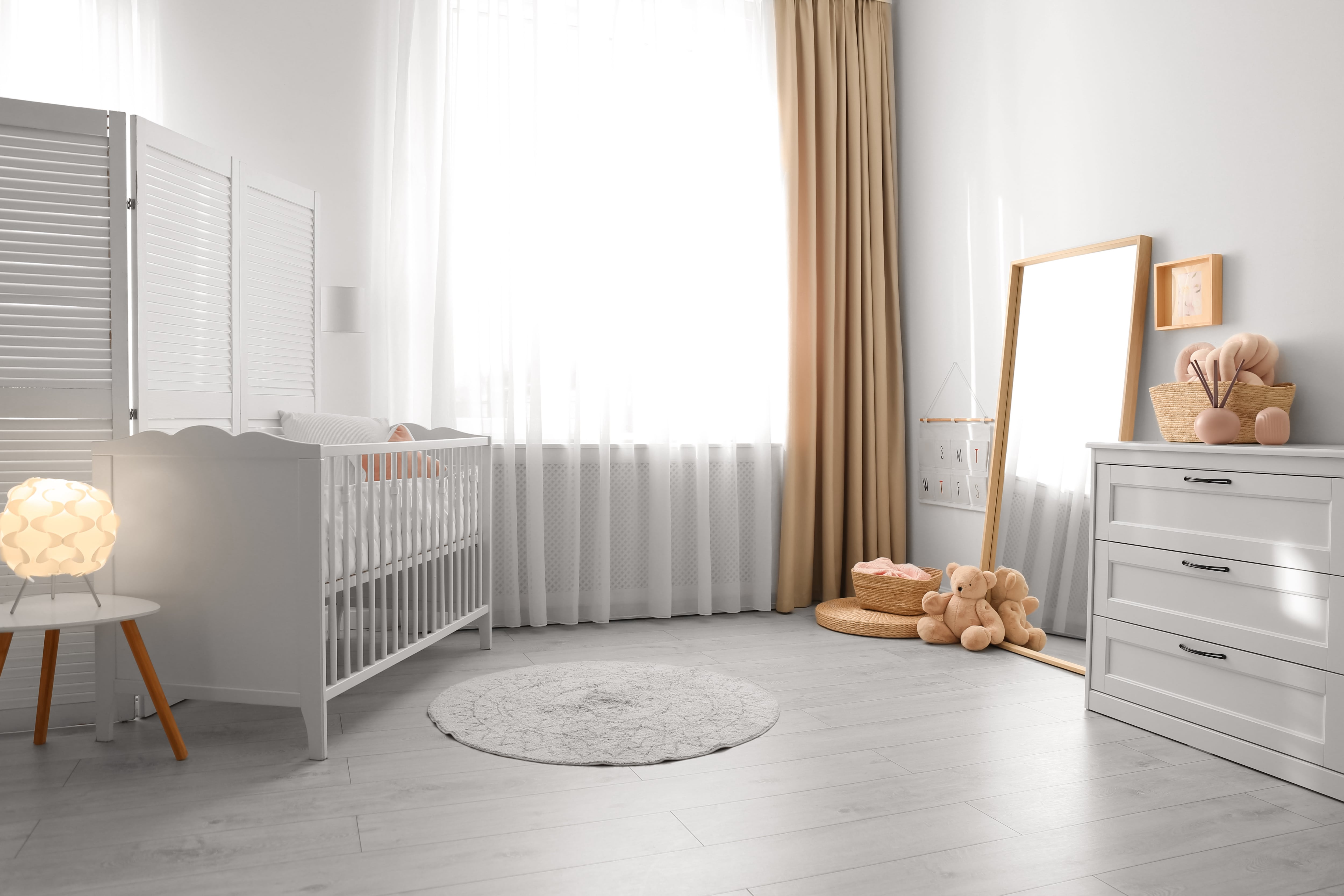 All-white nursery with tan curtains