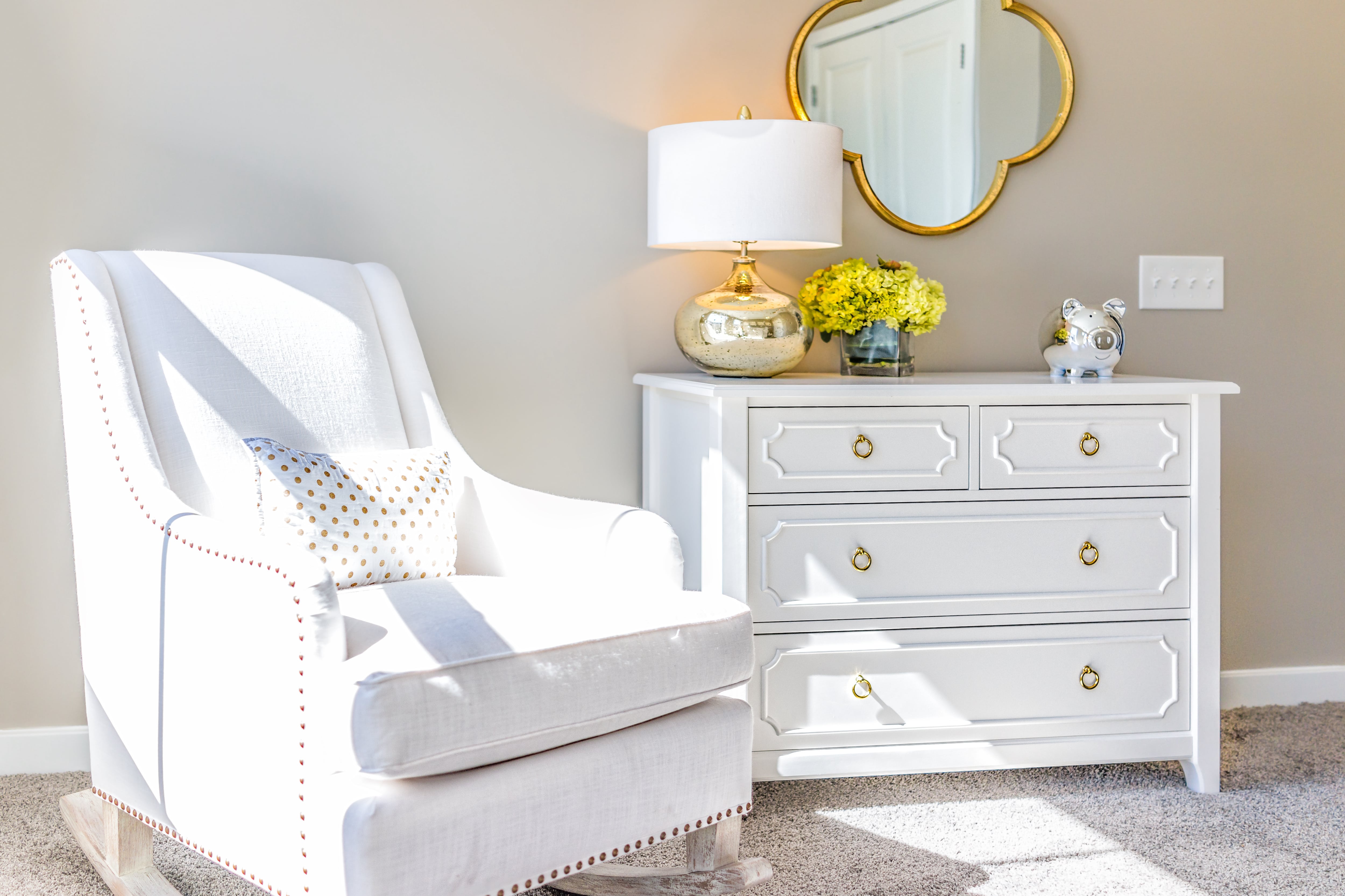 Nursery with comfortable white rocking chair 