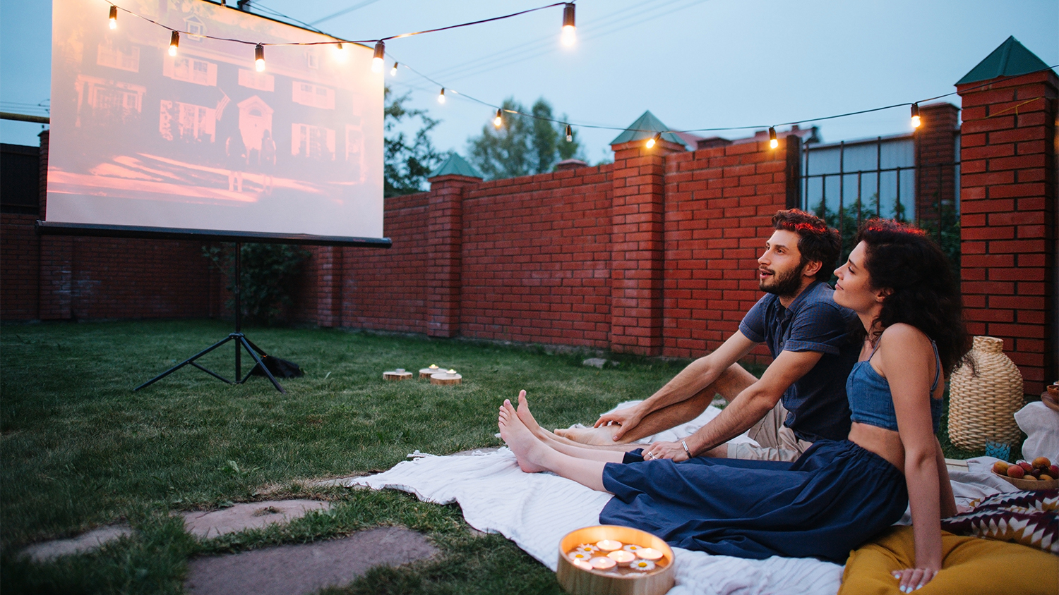 couple having outdoor movie night in yard