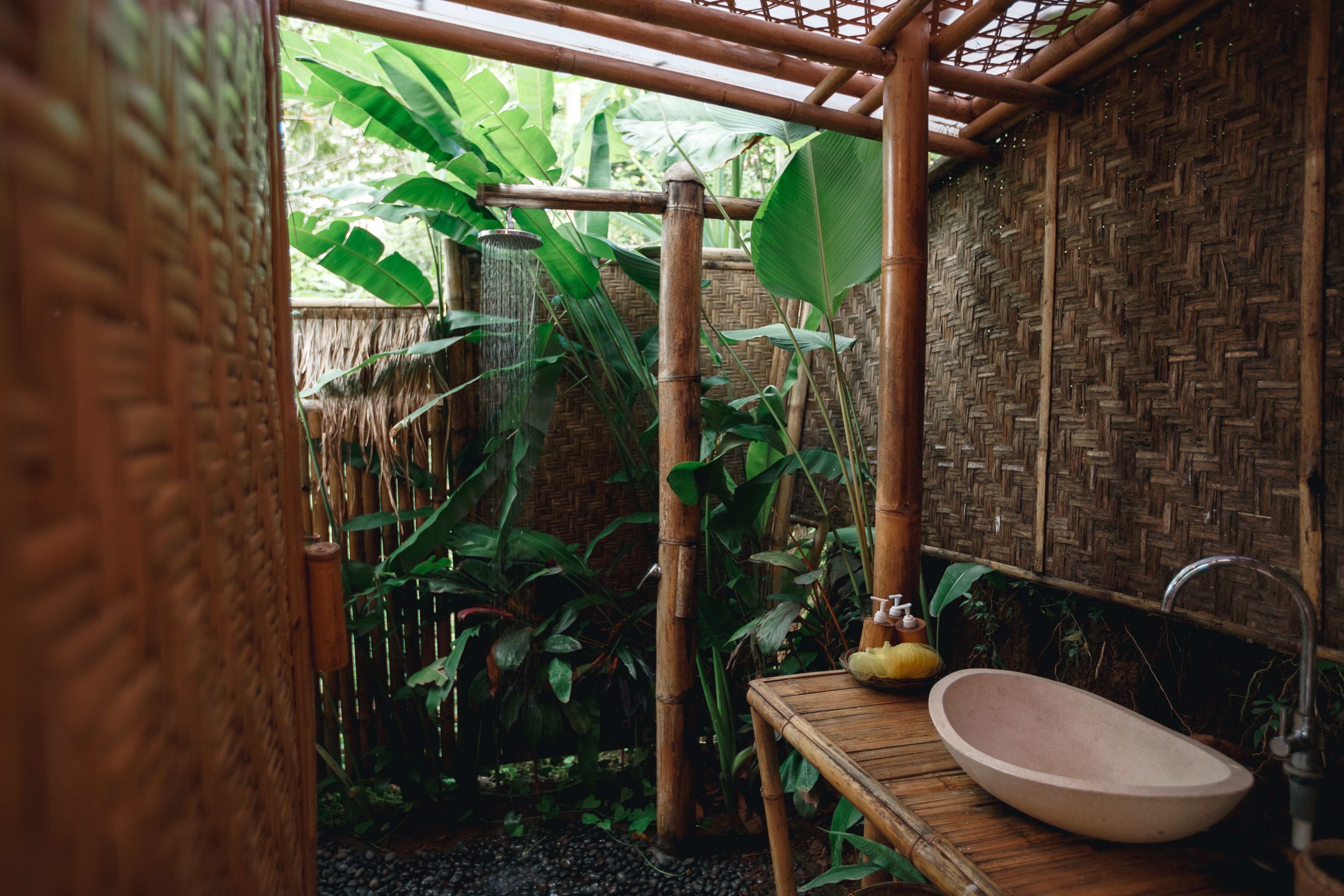 A bowl sink surrounded by bamboo walls and trellis