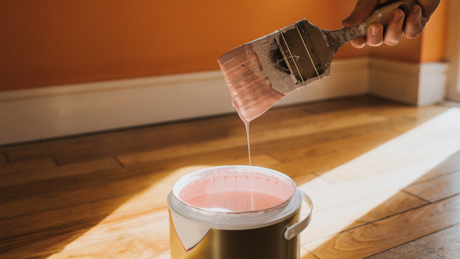 Paint brush dripping paint wood floor