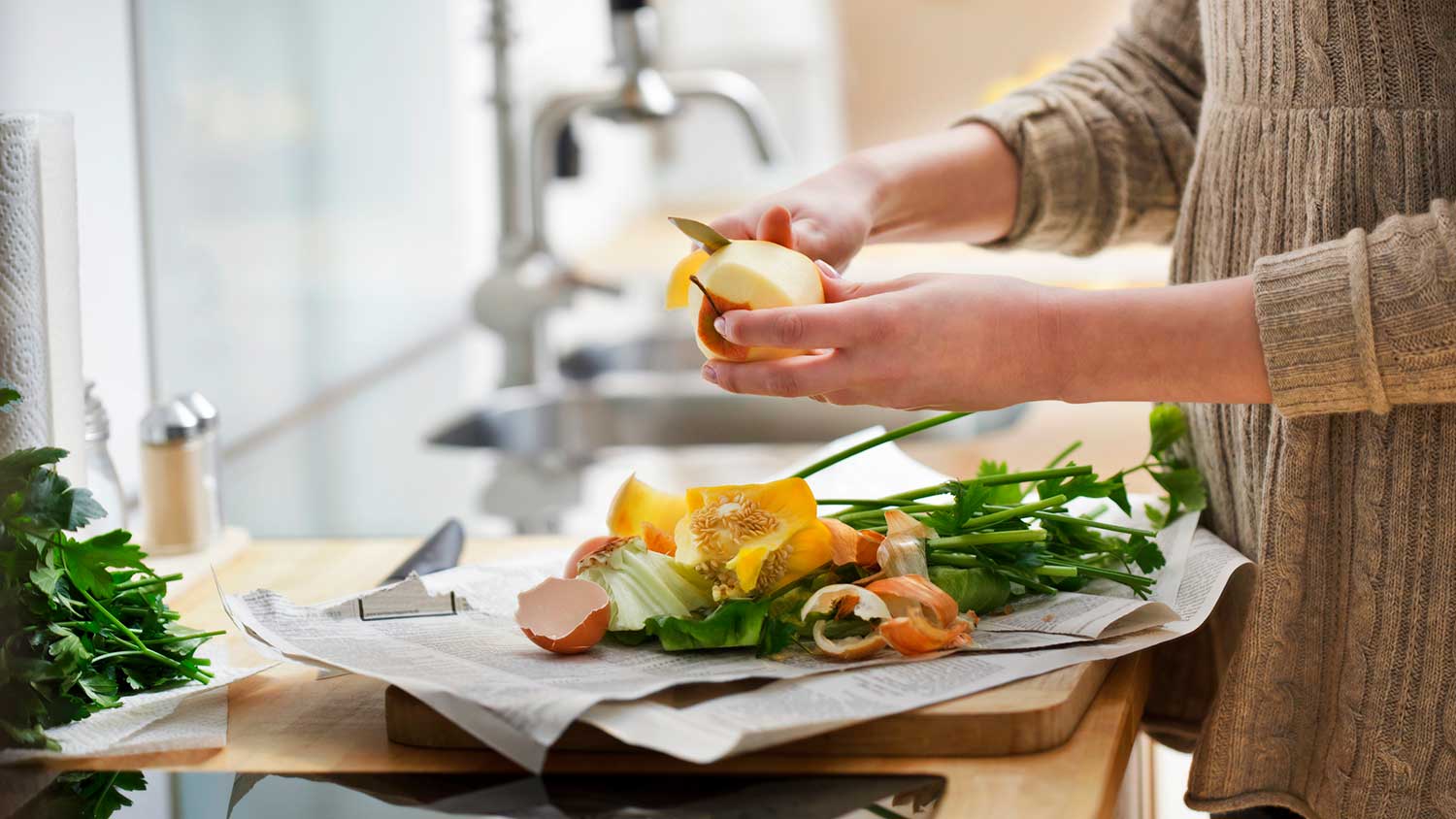 Woman using a knife to peel fruits and vegetables