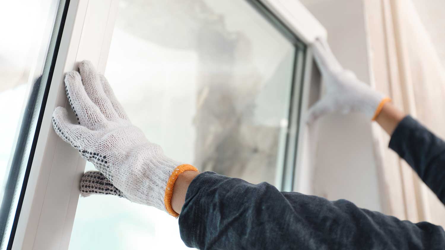 Person replacing a window in home