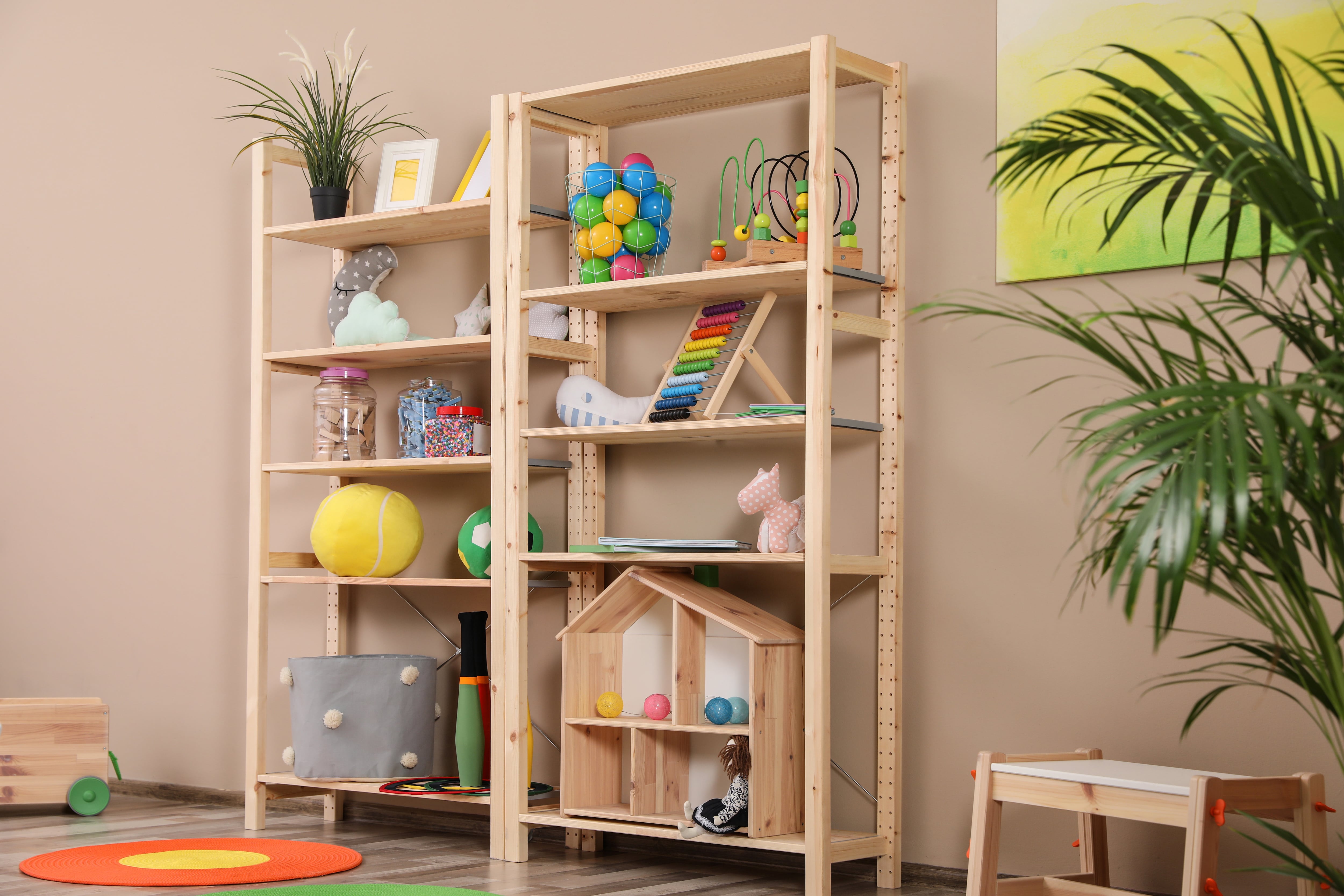 Tall wooden storage shelves storing toys in a playroom