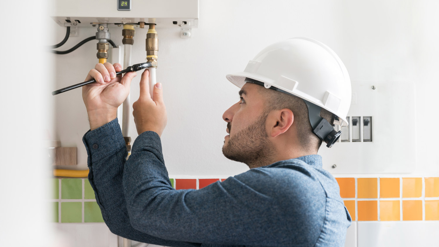A plumber repairing a furnace’s pipes
