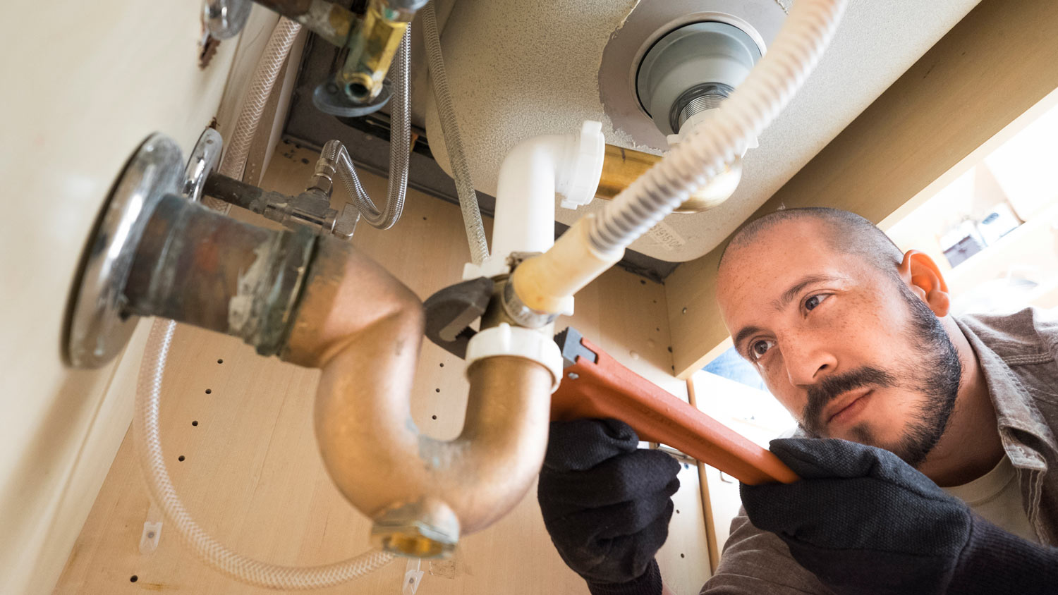 A plumber repairing a kitchen sink