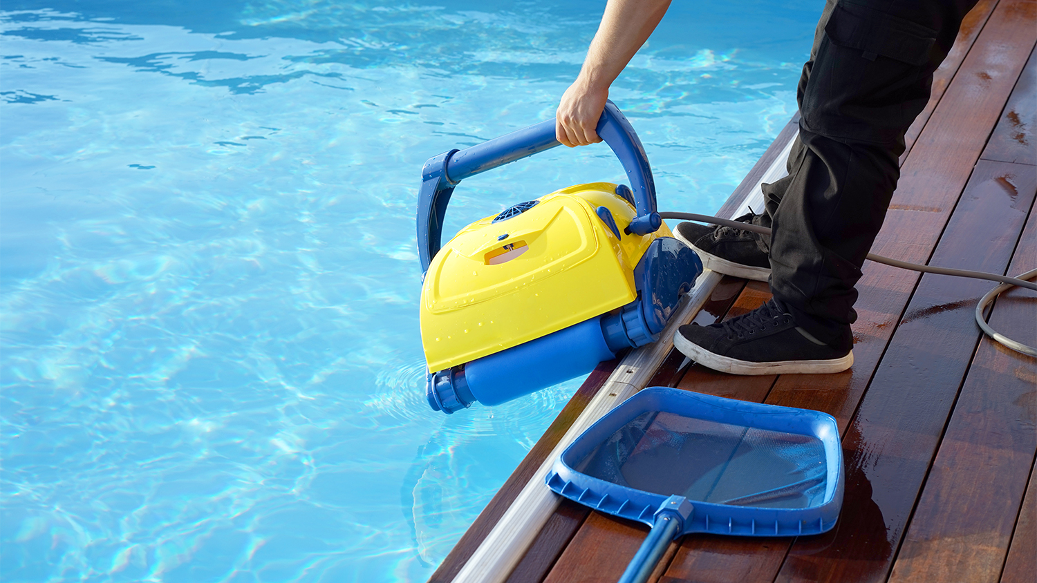 man cleaning pool with robot vacuum