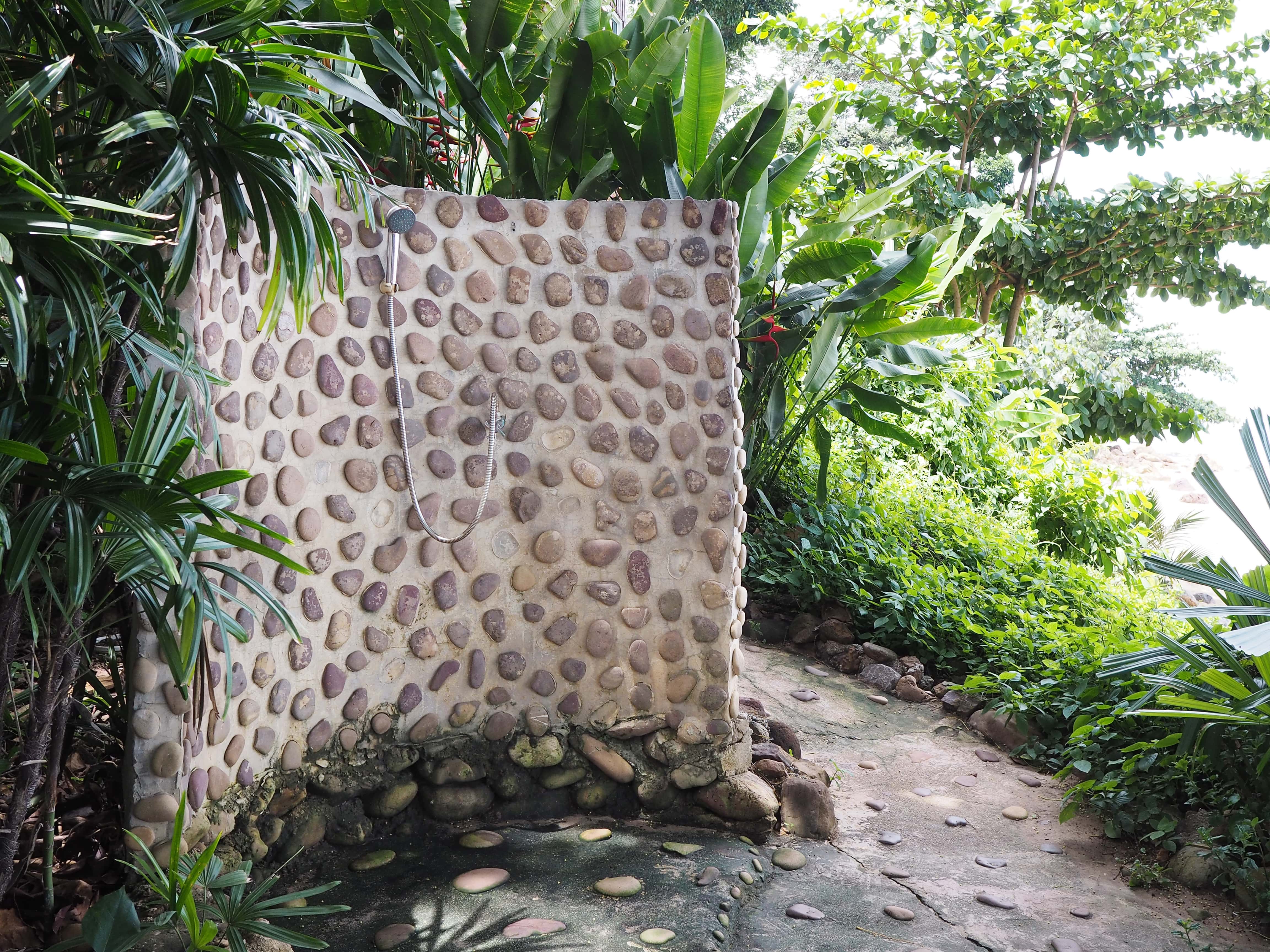 An outdoor shower built into a rock wall