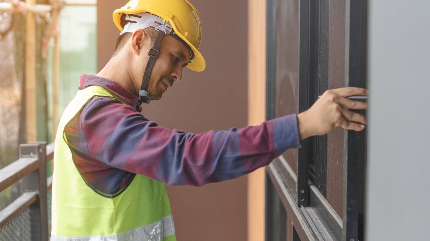 A professional inspecting a house’s sliding windows