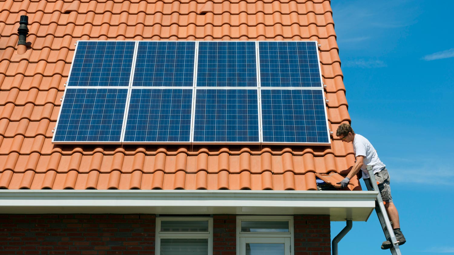 A professional inspecting solar panels on a roof