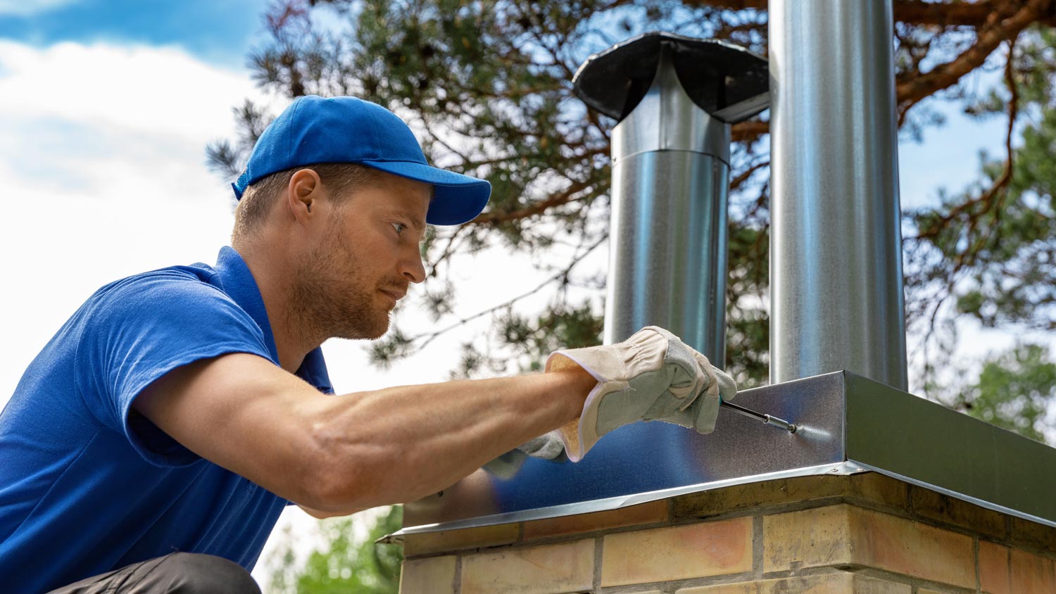 A professional installing a metal chimney cap