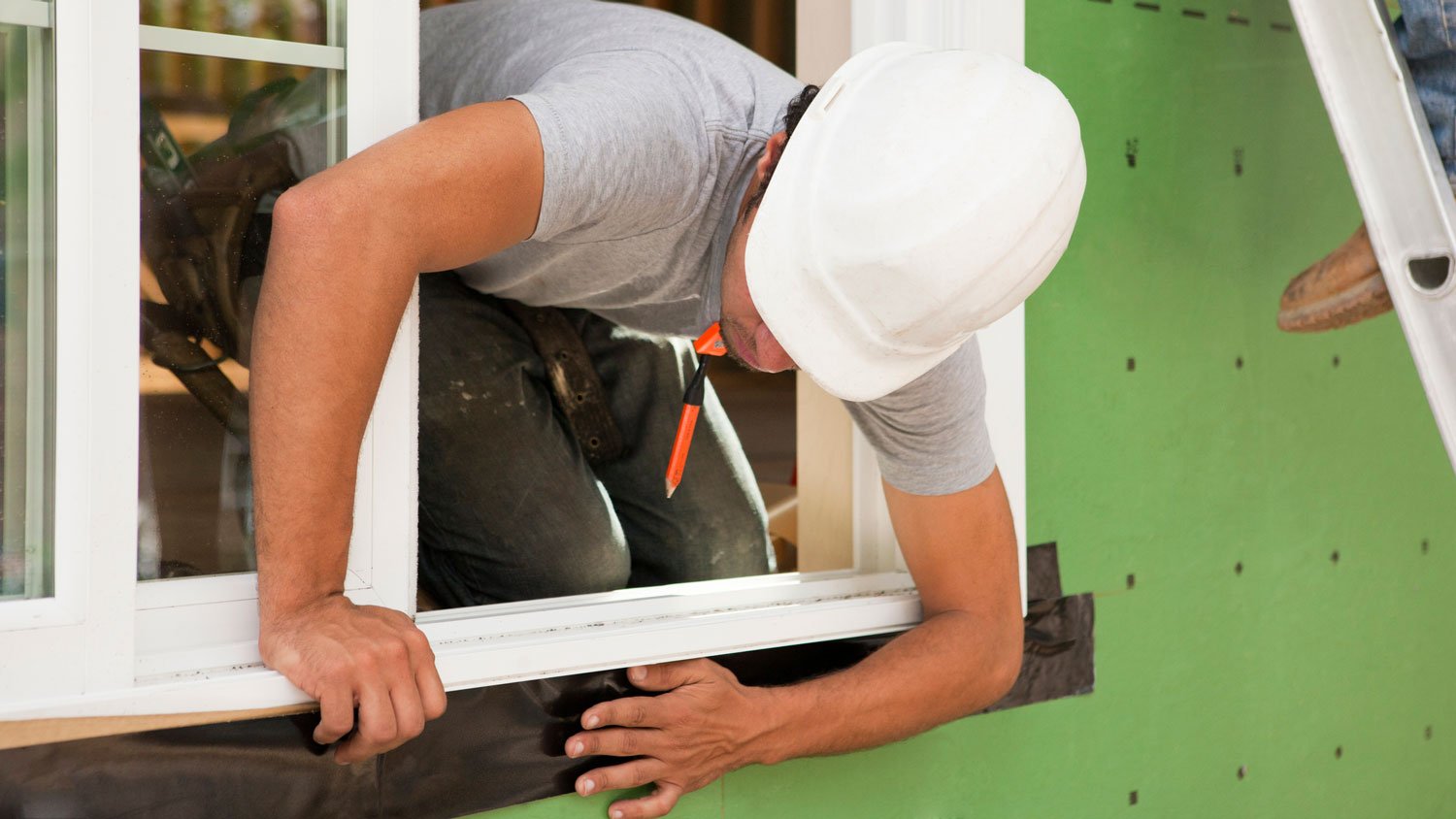 A professional installing a new window frame