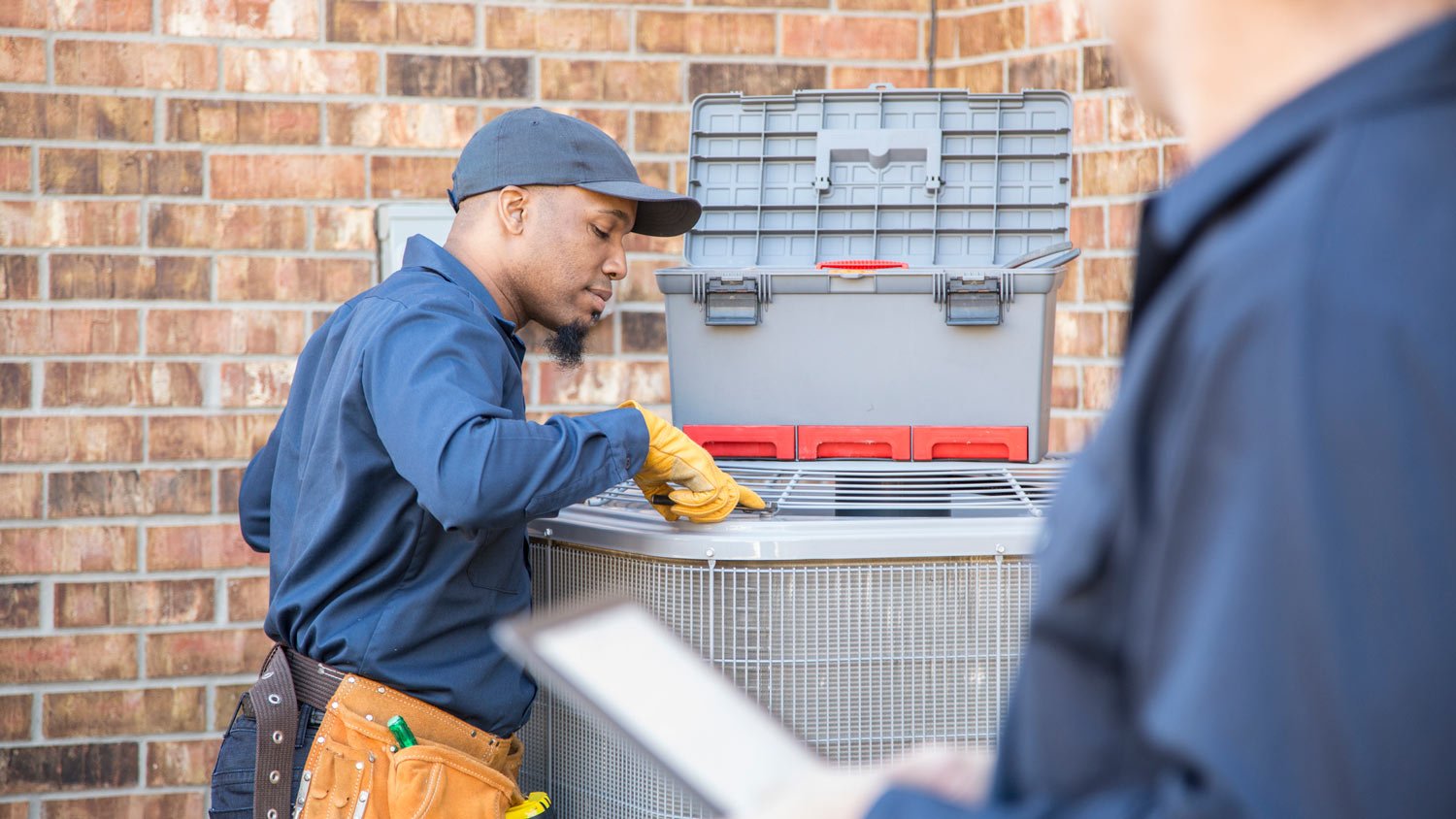 Two professionals inspecting an HVAC system
