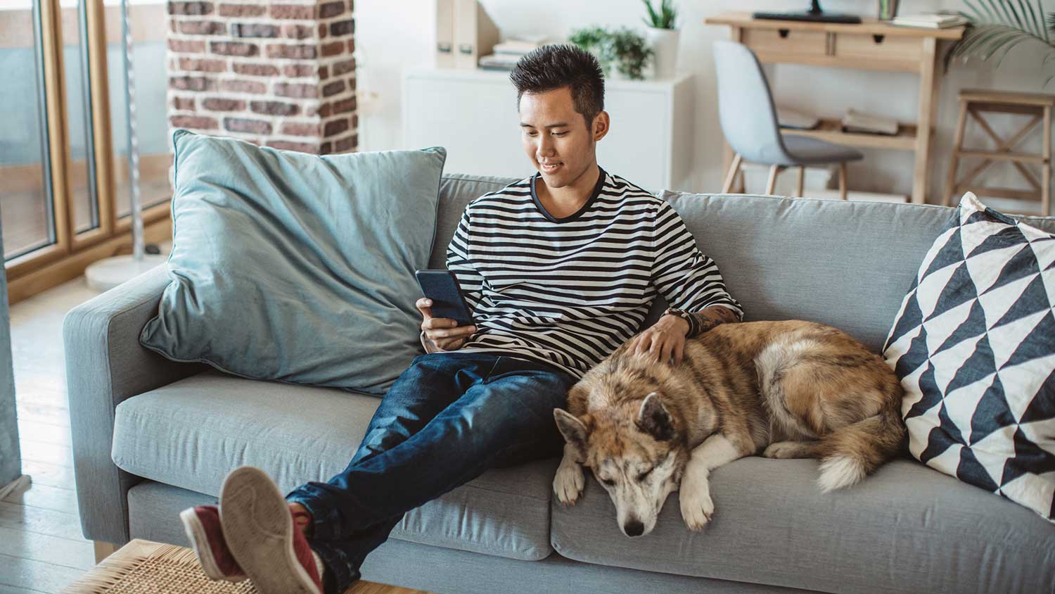 Young man sitting on the couch with his dog