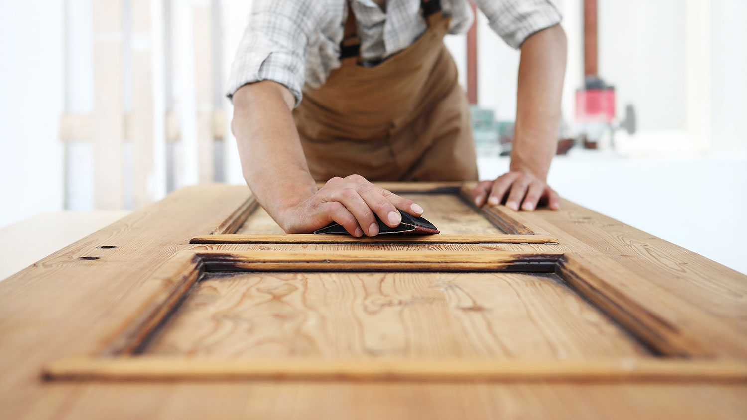 Carpenter sanding wood door