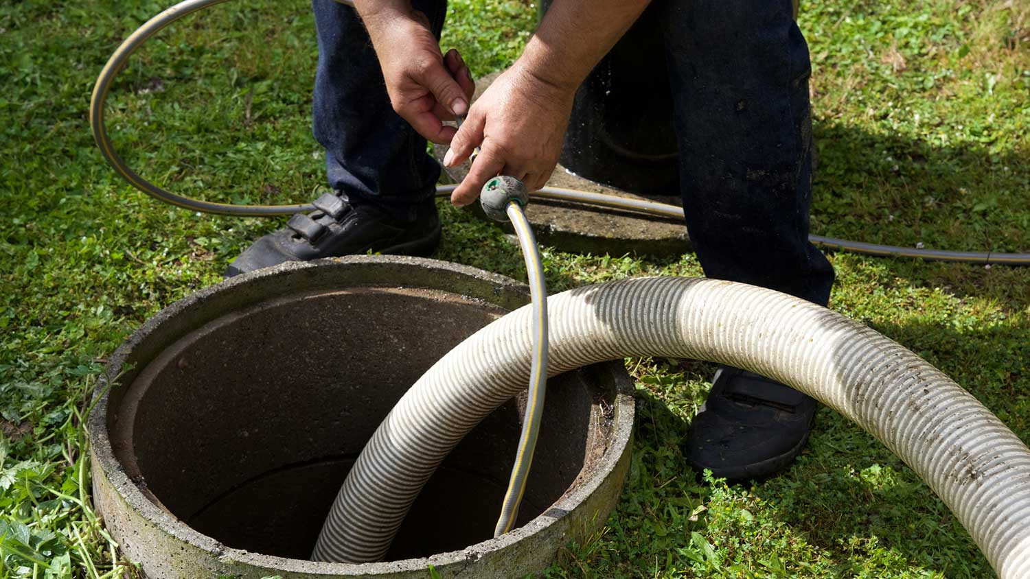 Worker pumping septic tank