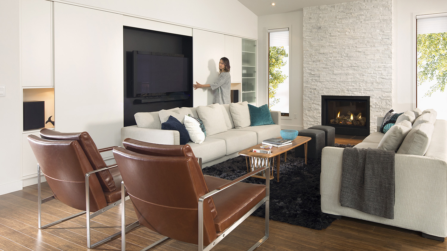 woman sliding cabinet door to expose TV