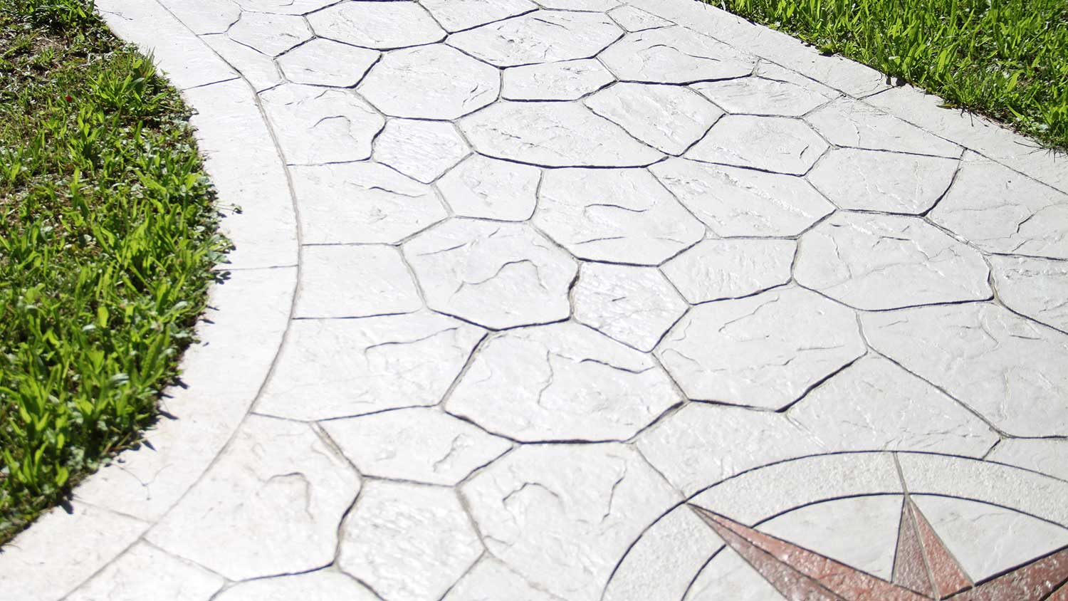 Stamped grey concrete walkway in a yard