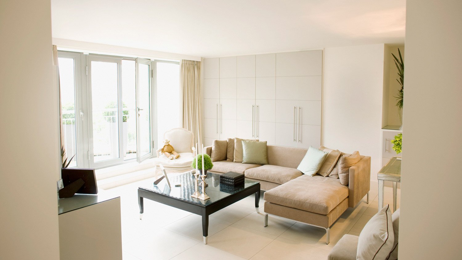 A sunny living room with a glass tabletop on the coffee table