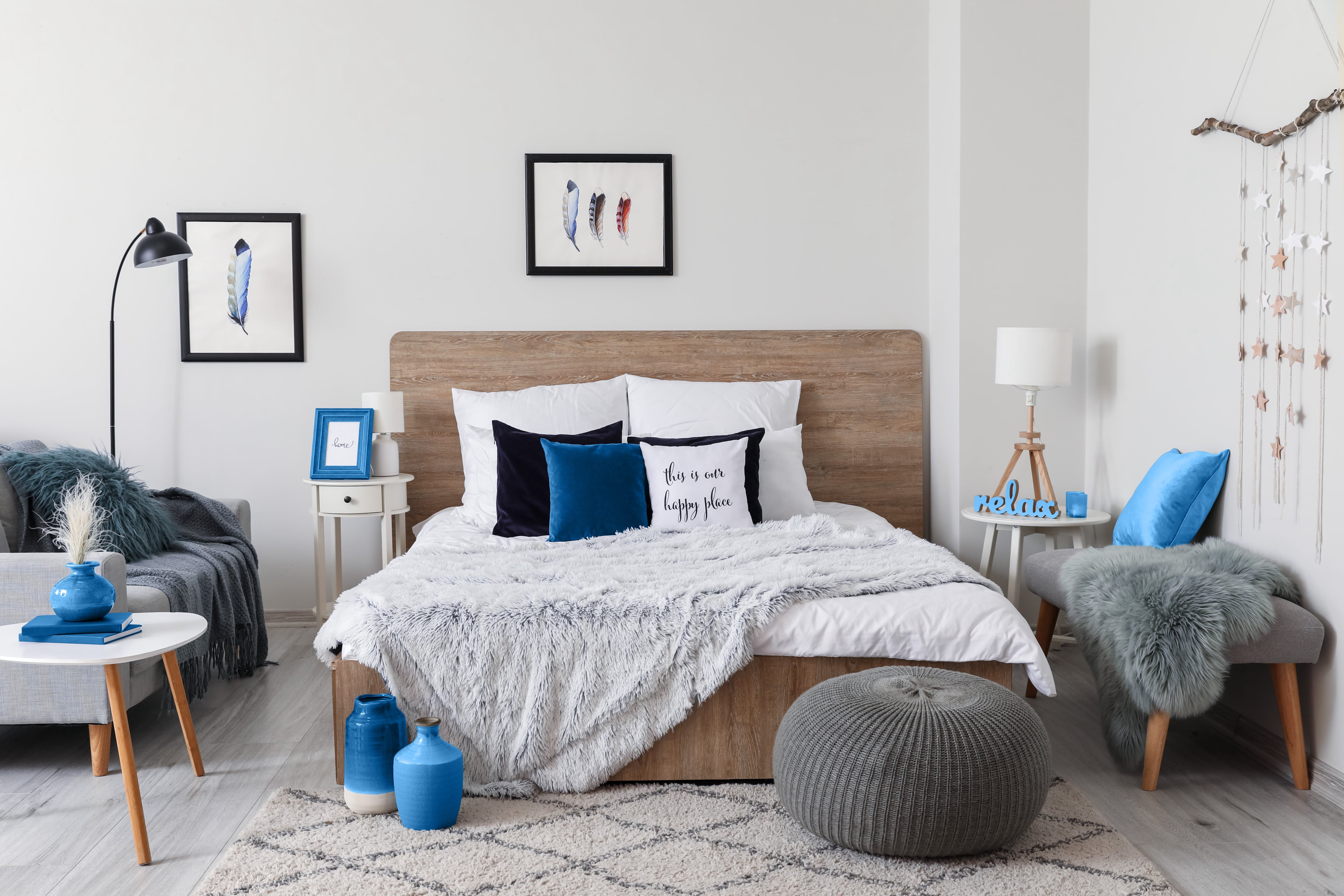 ray bedroom with blue accents, couch, side table, bench, and ottoman