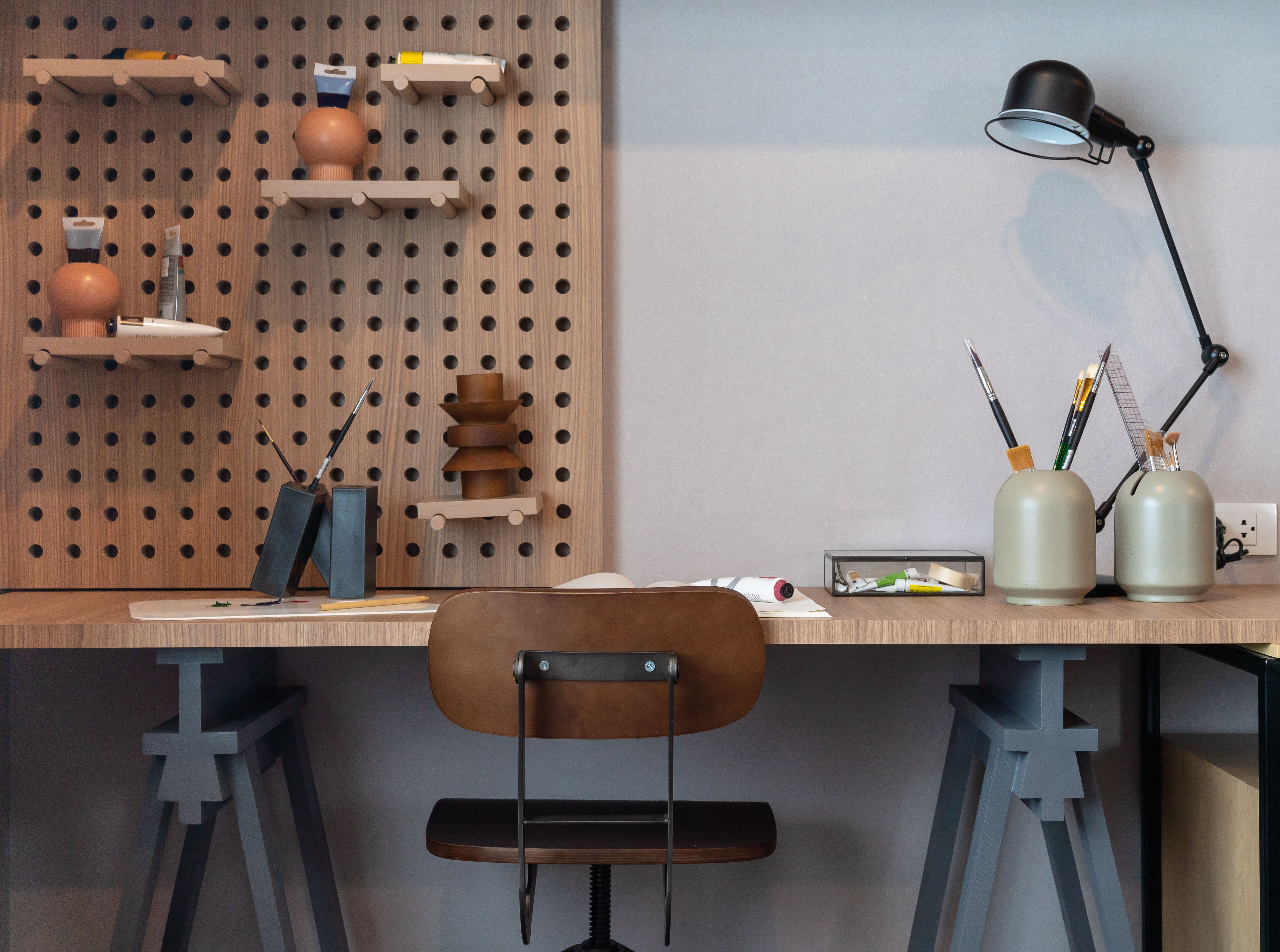 Modern wooden desk with pegboard in teen bedroom