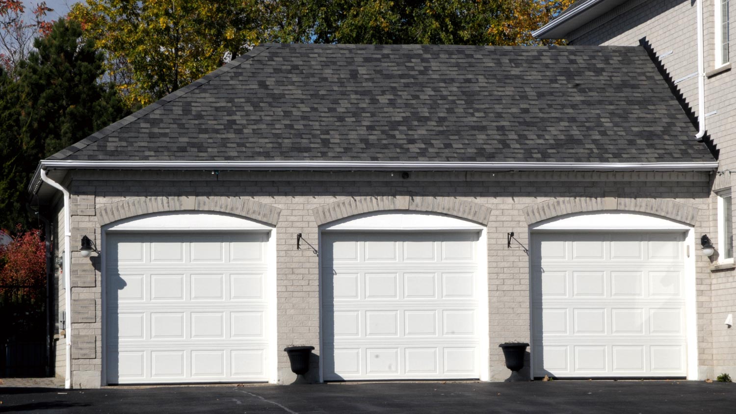 A triple garage with white doors