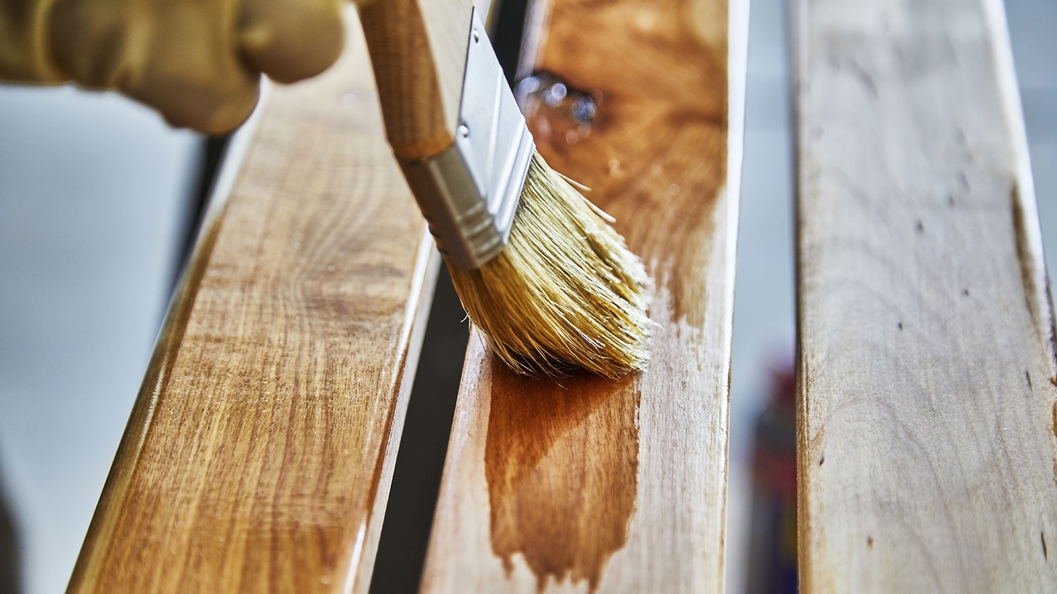 Using brush to varnish a wooden furniture
