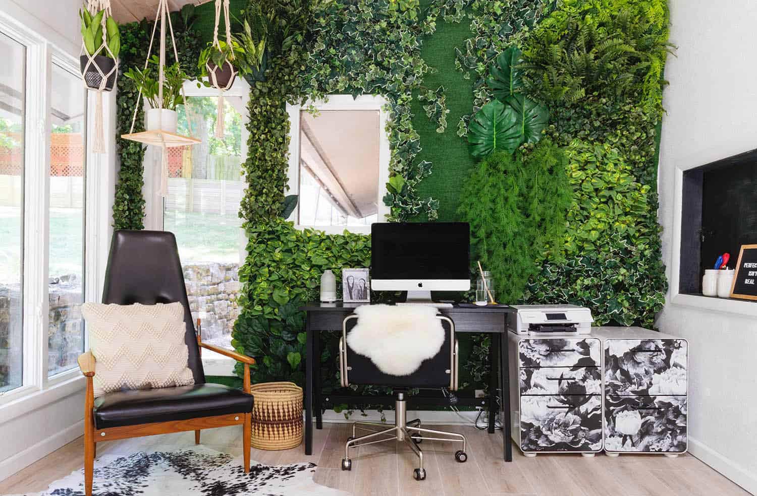 A vertical wall filled with plants in a home office