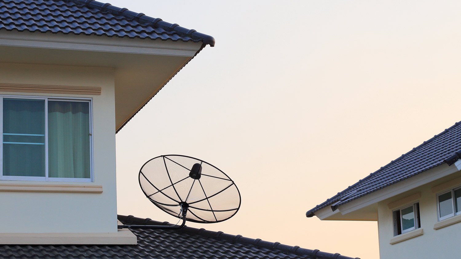 A visible satellite dish on the roof of a house