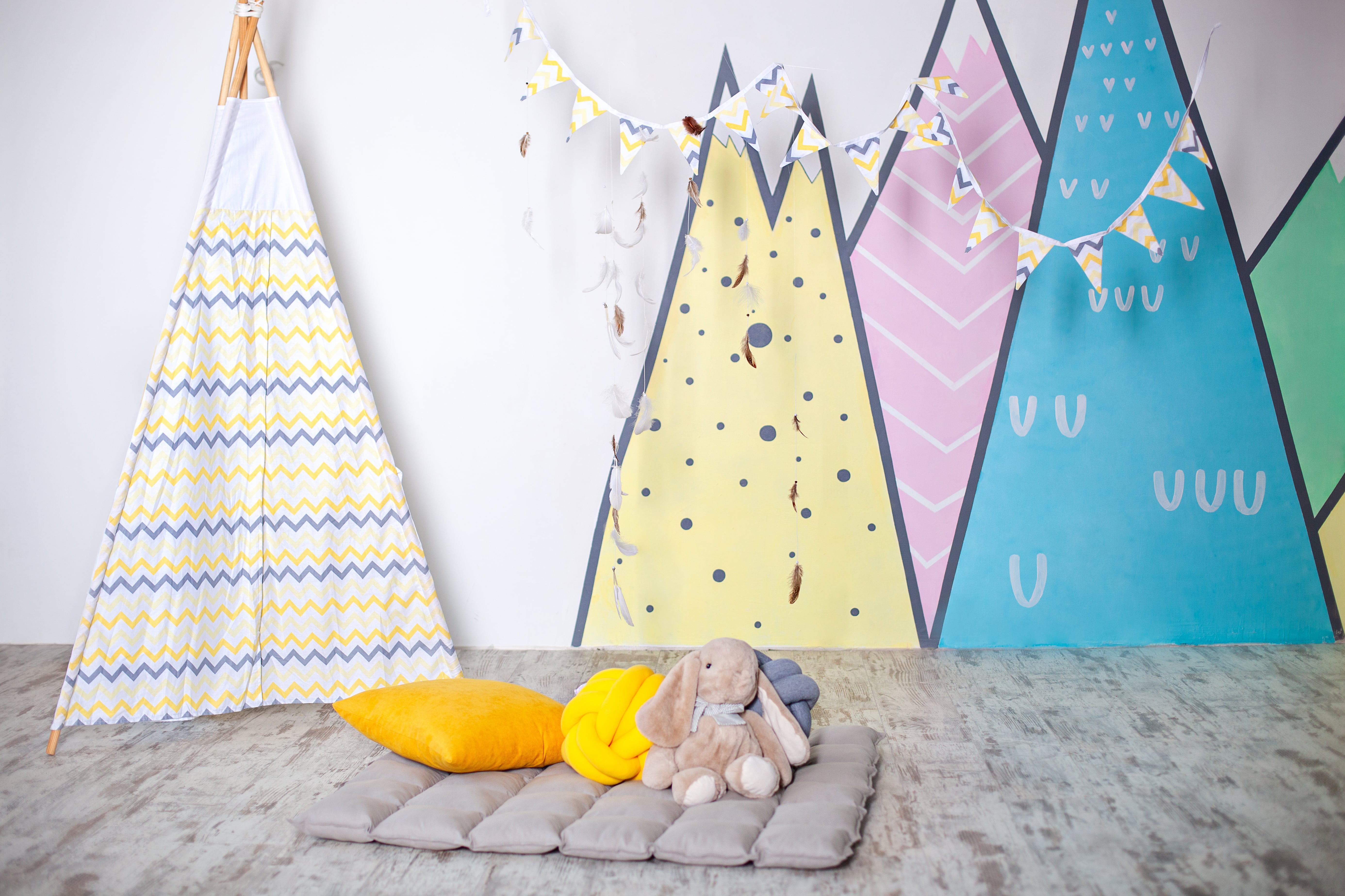 A kid’s room with a tent and mountain wall decals