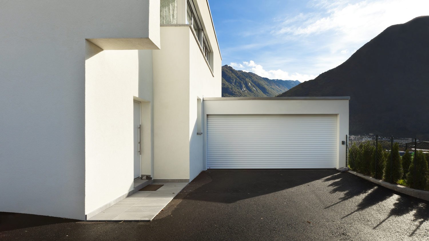 A single door white garage next to the house 