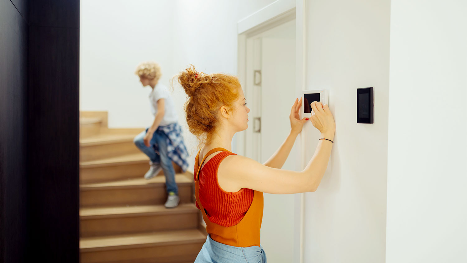 Woman adjusting thermostat