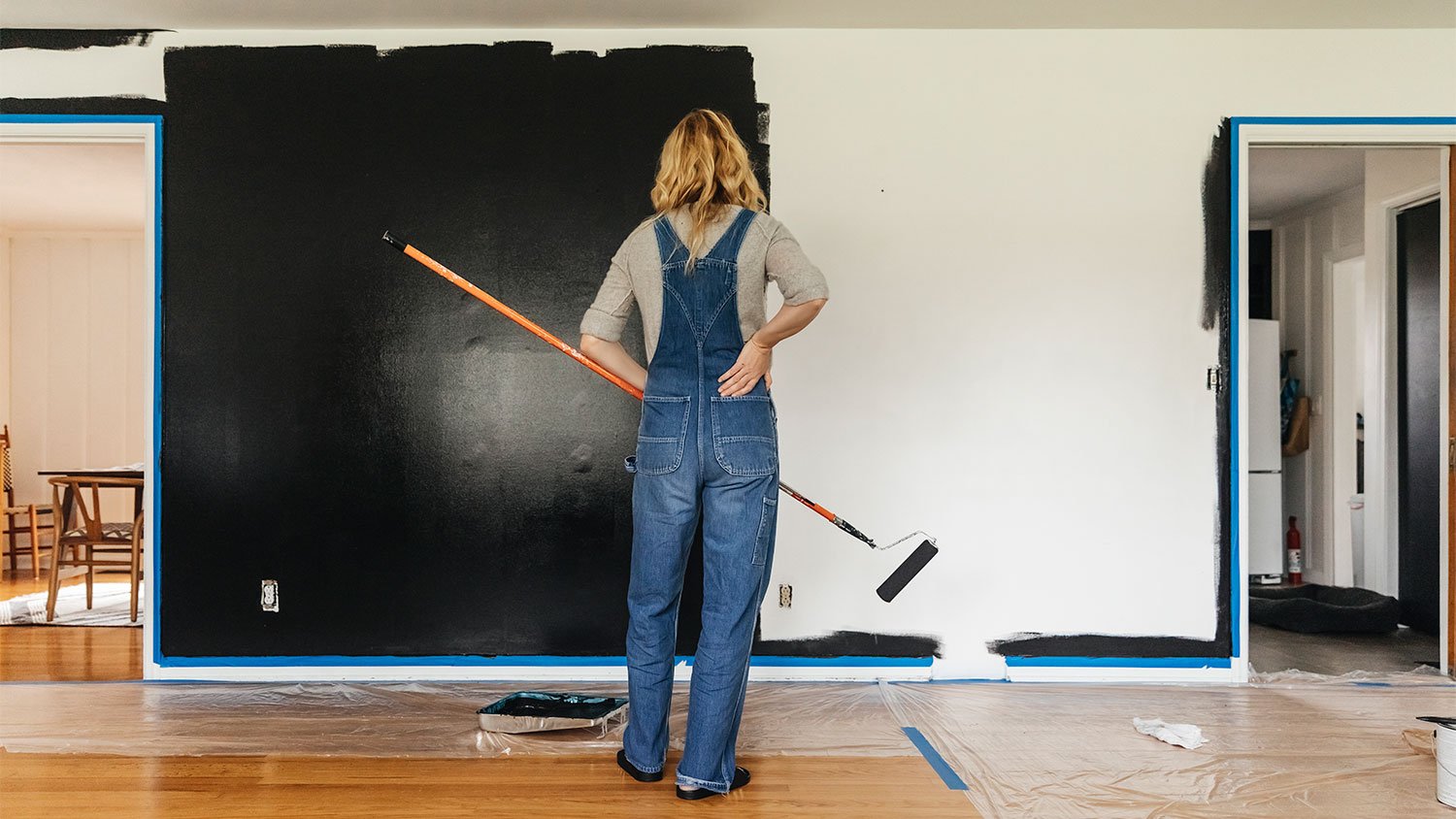 Woman painting wall black