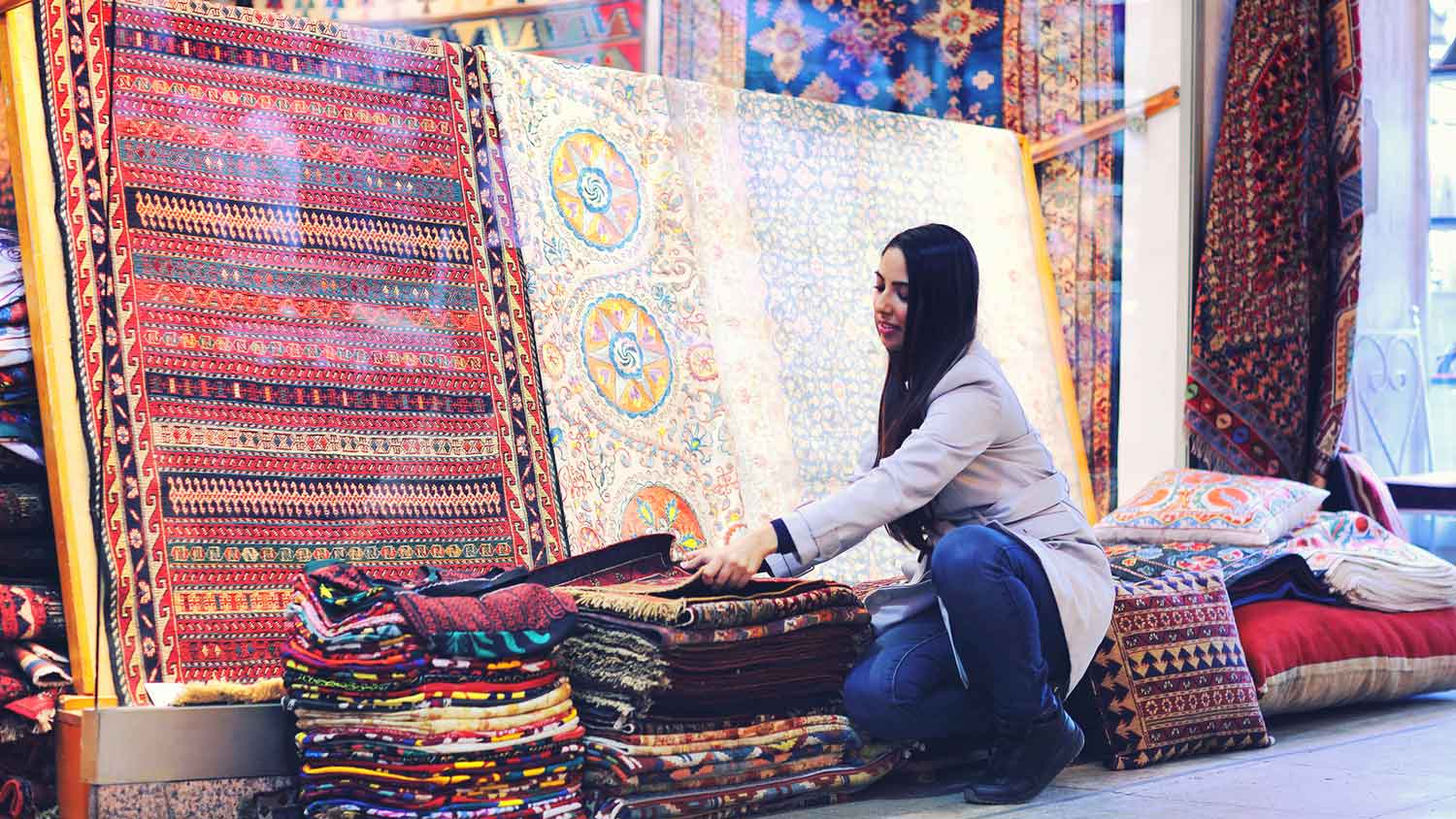 Woman looking at beautiful rugs in a bazaar