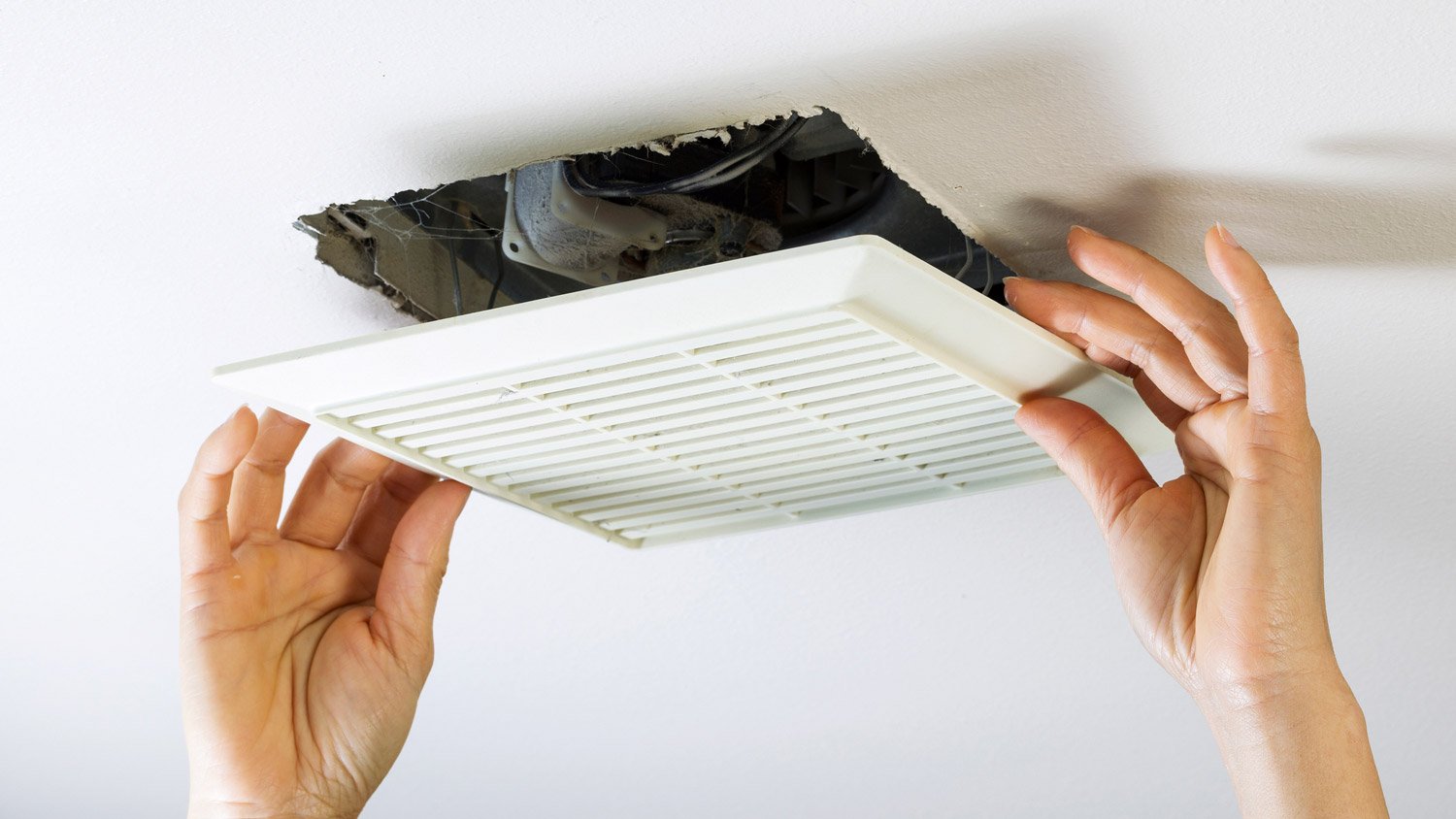 A woman cleaning an air duct