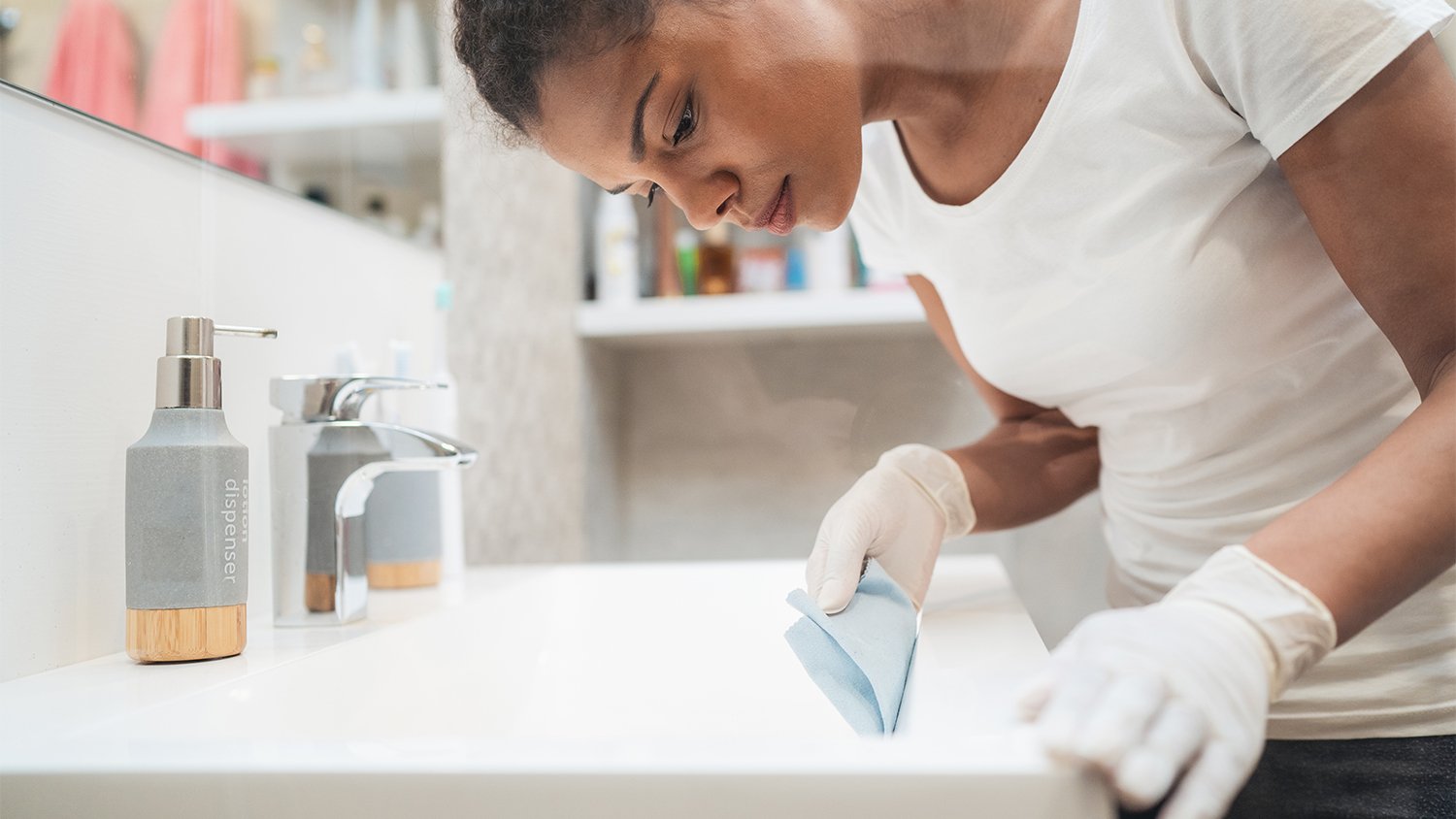 woman wiping down bathroom sink