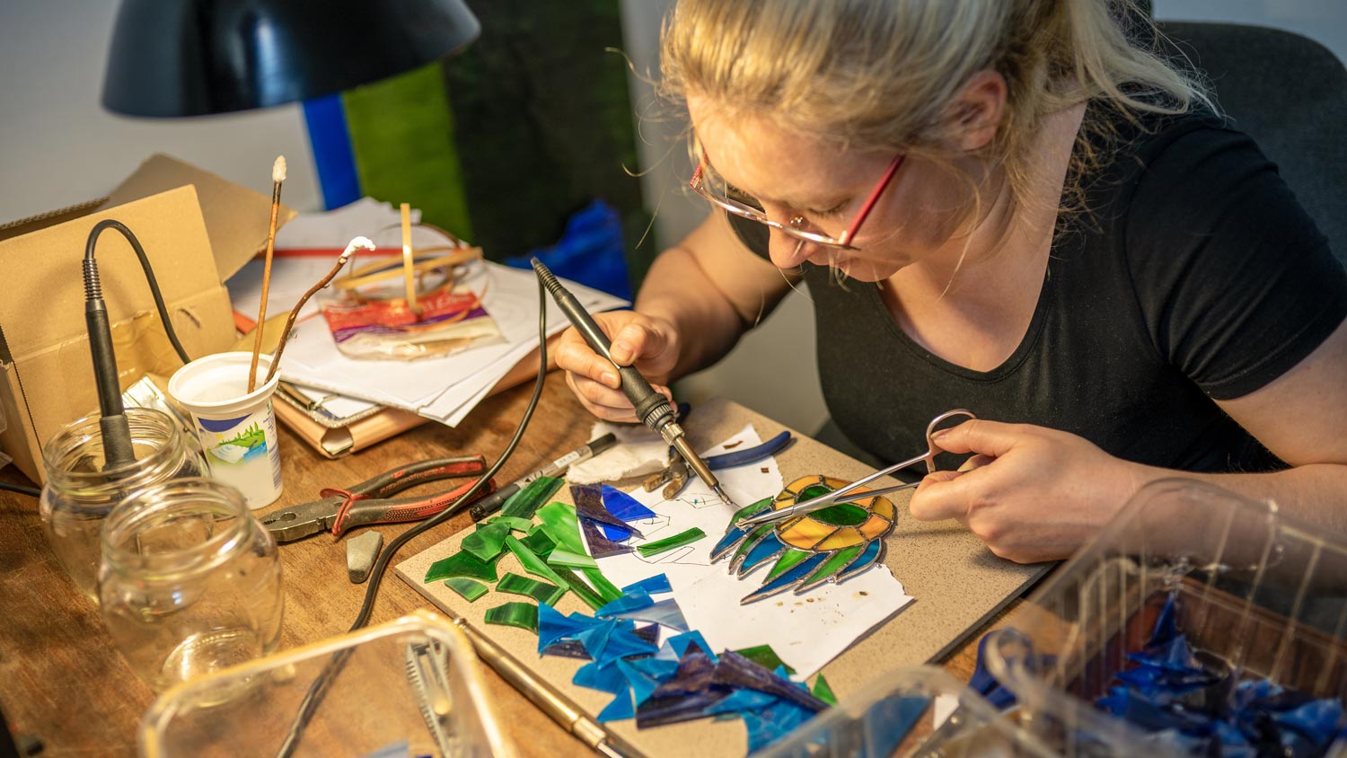 A woman working with stained glass