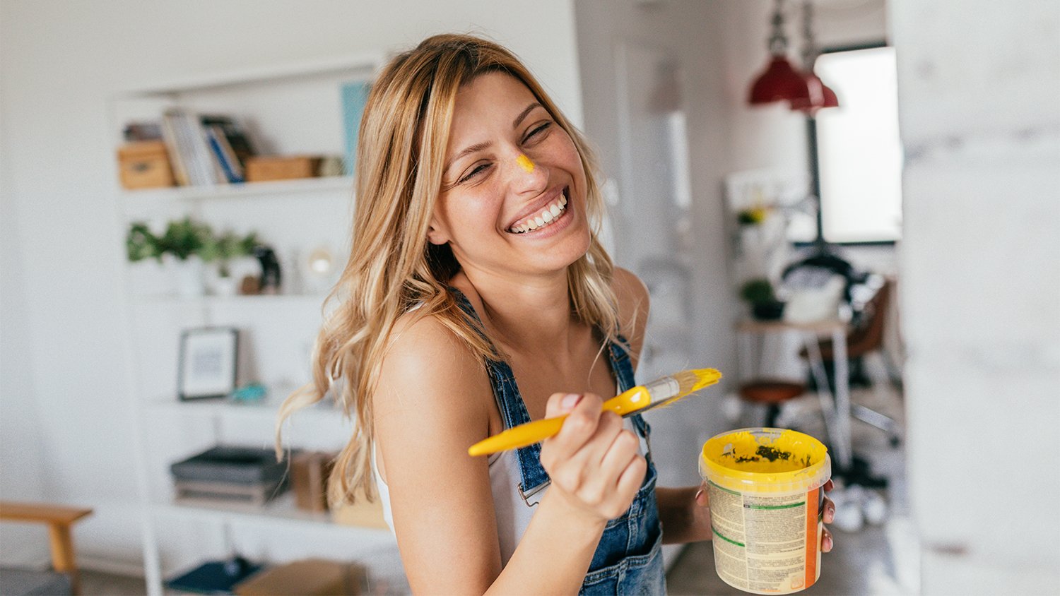 woman smiling painting with yellow paint